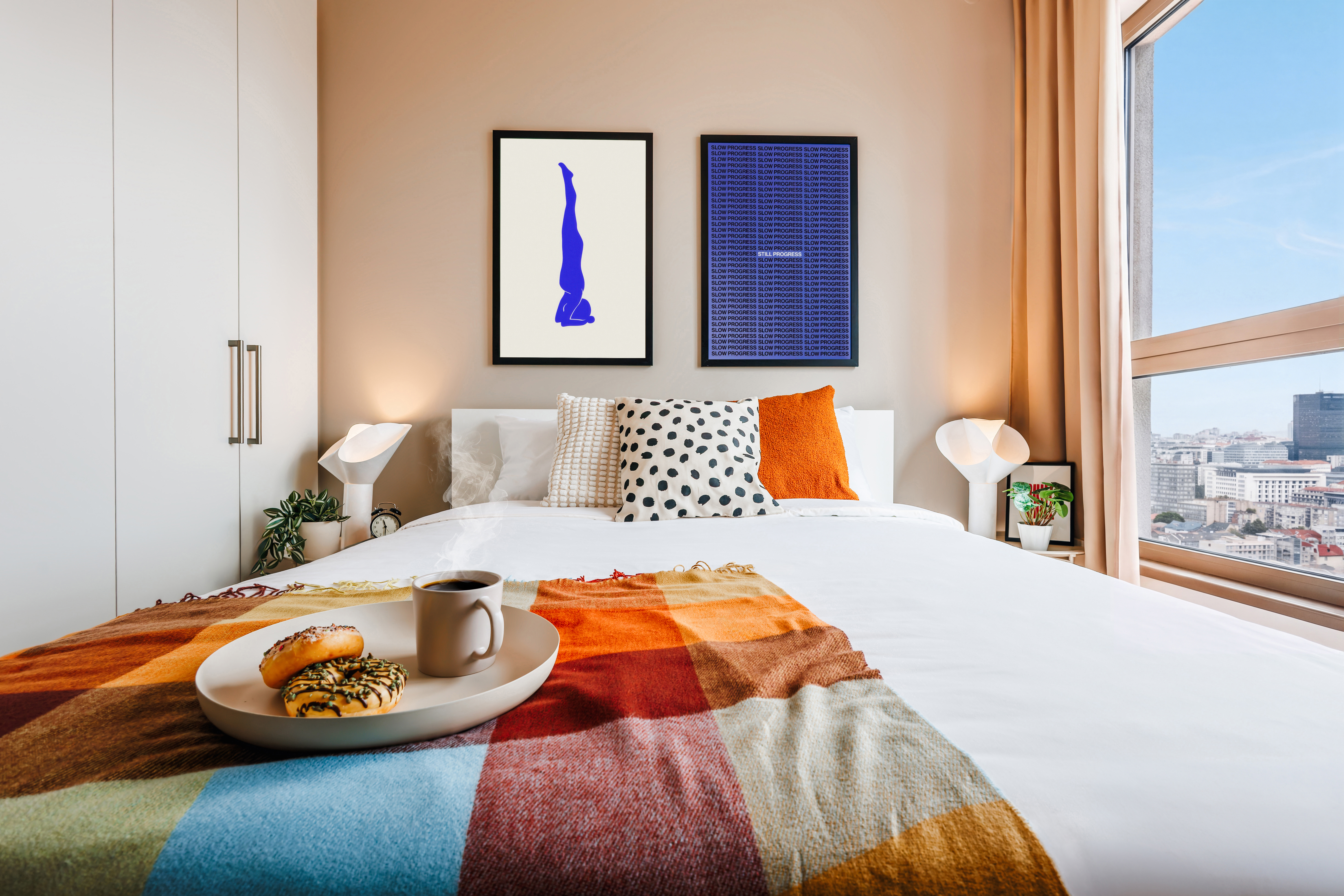 Bright modern bedroom with city views and cozy designer touches