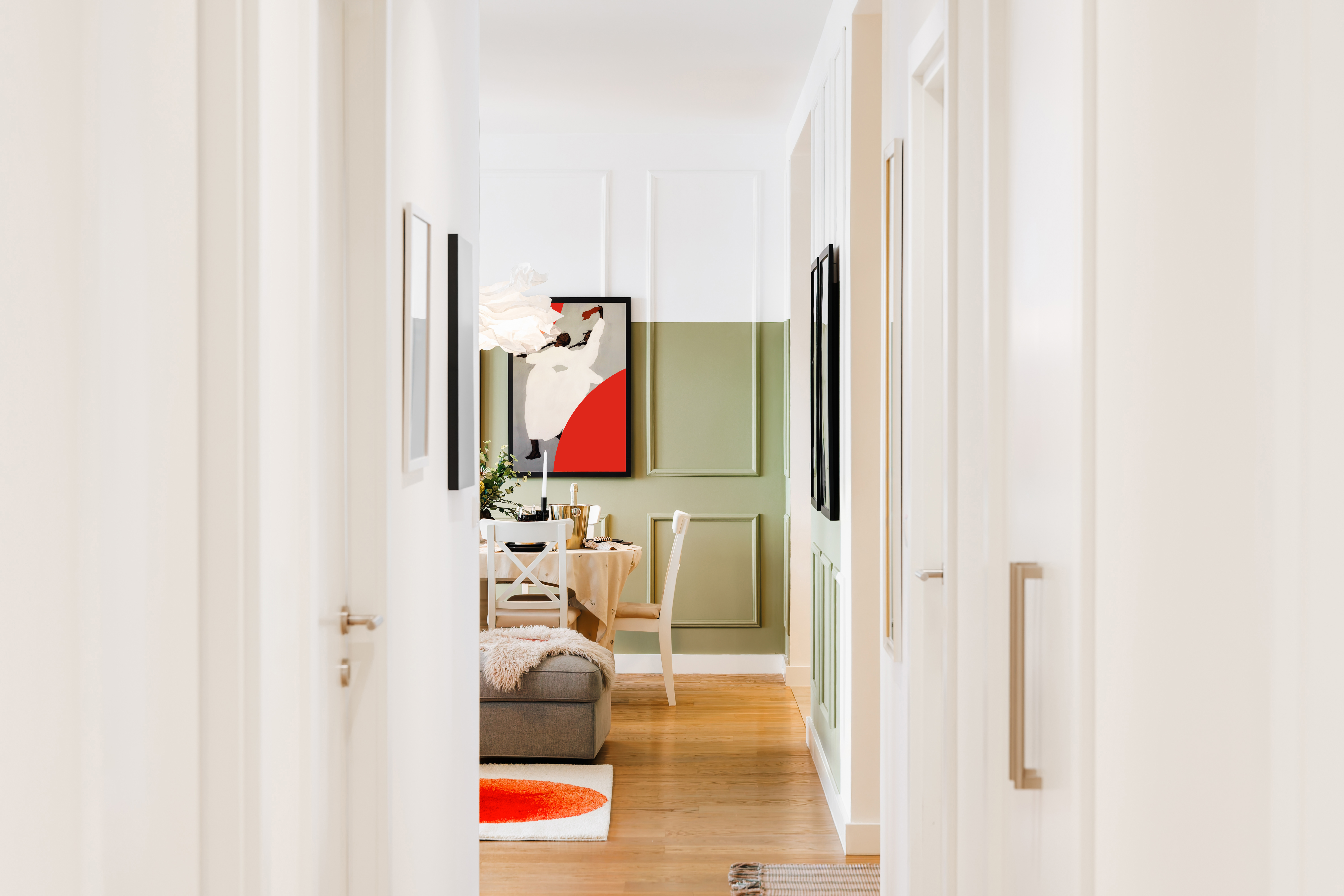 Bright modern hallway leading to a chic, art-filled dining space