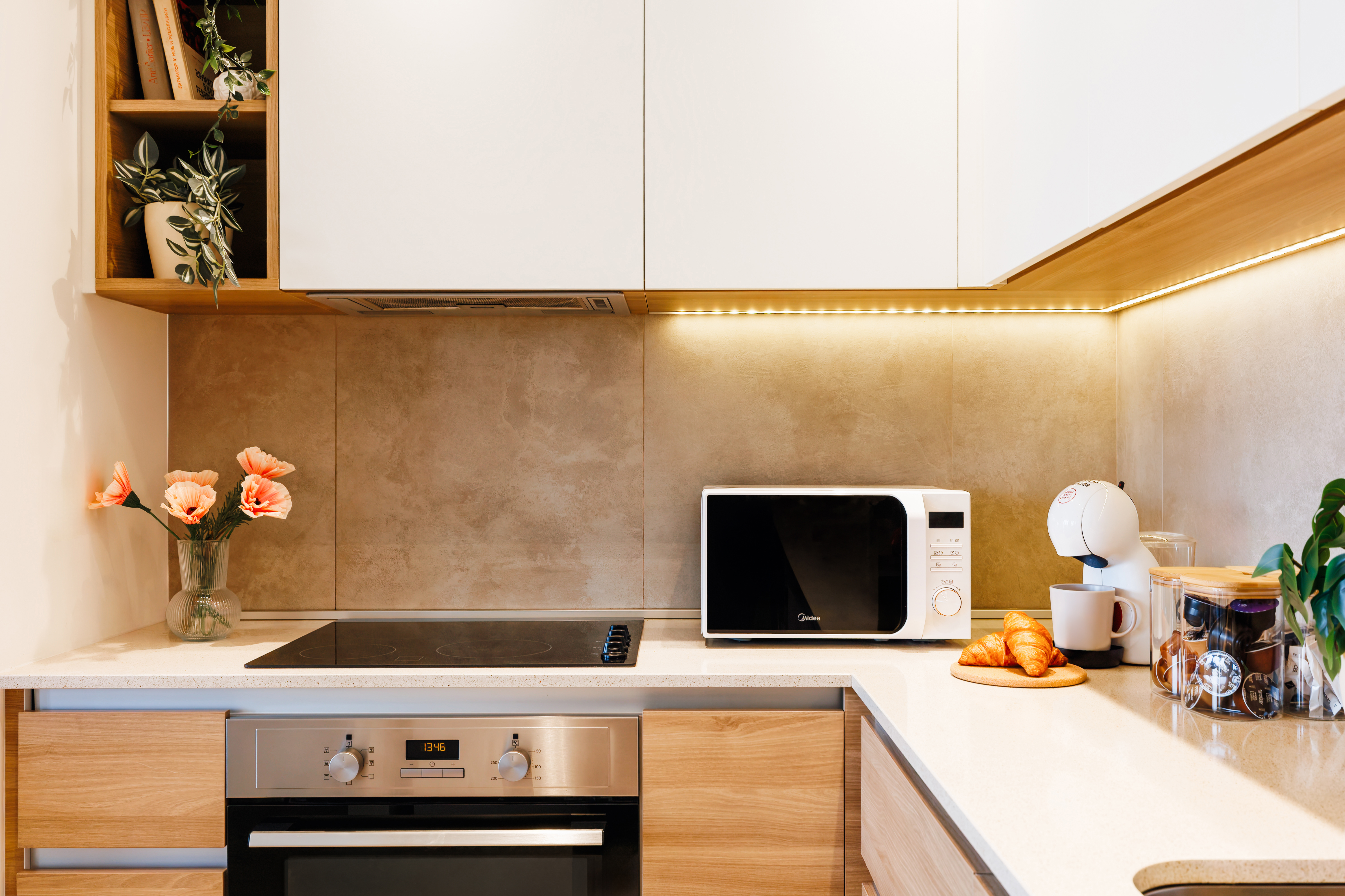 Bright modern kitchen with coffee station, warm lighting, and sleek finishes