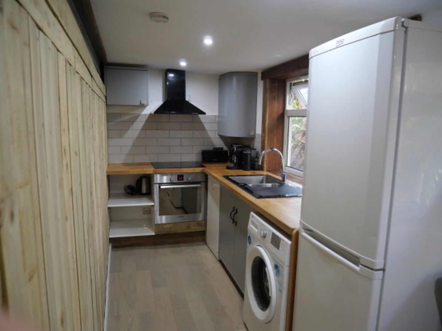 Bright, modern kitchen with full appliances and warm wood finishes