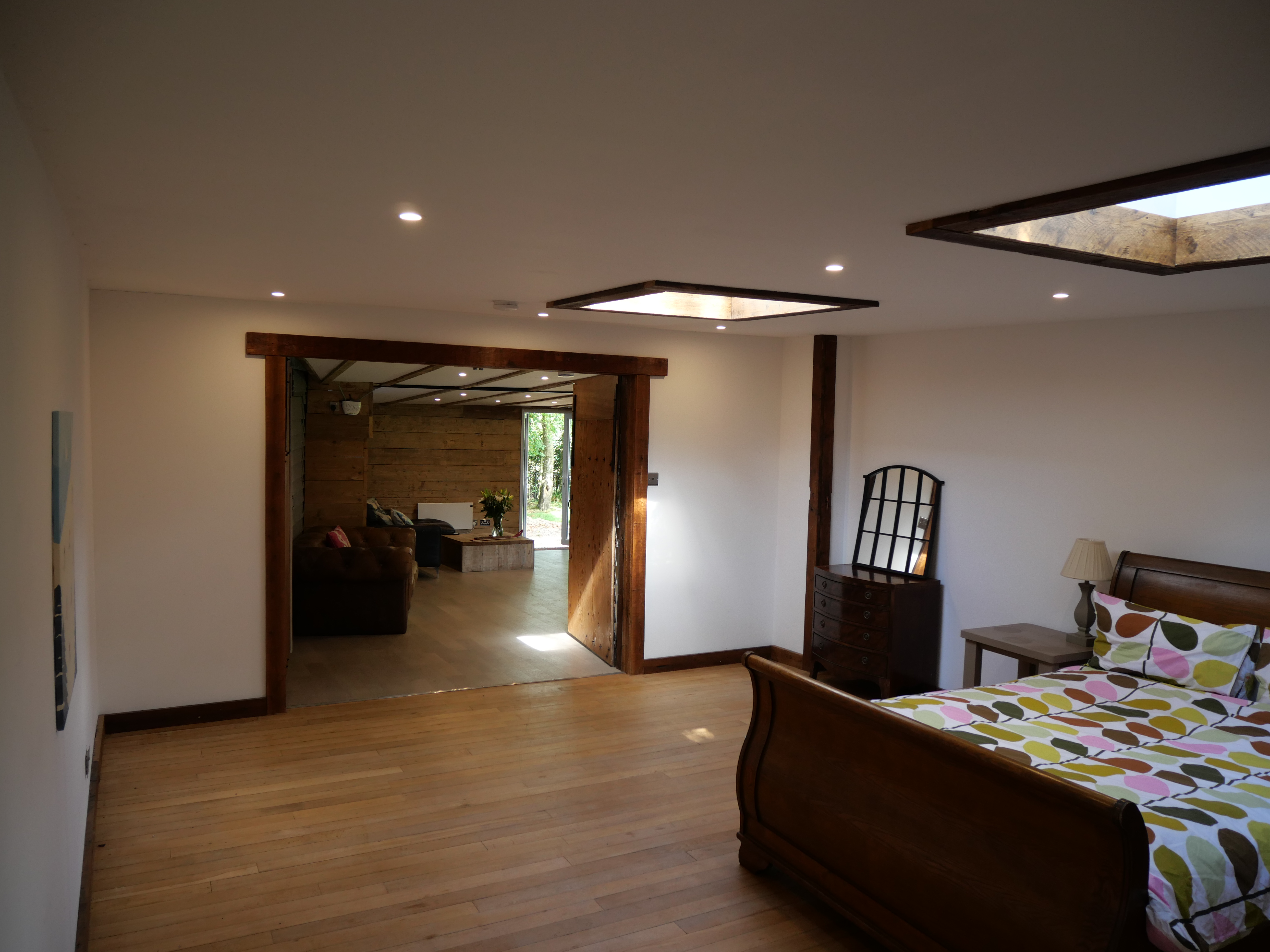 Spacious wood-accented bedroom with skylights and lounge access
