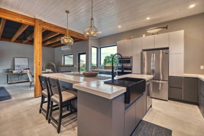 The kitchen: white concrete island, full-size appliances, beverage fridge