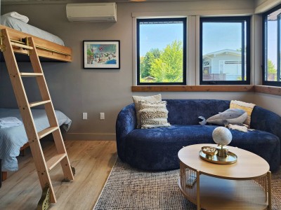 The bunk room: bunks, a curved sofa, windows on two sides