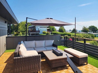 The rooftop deck: turf, lounge seating and a fire table, the sea on the horizon