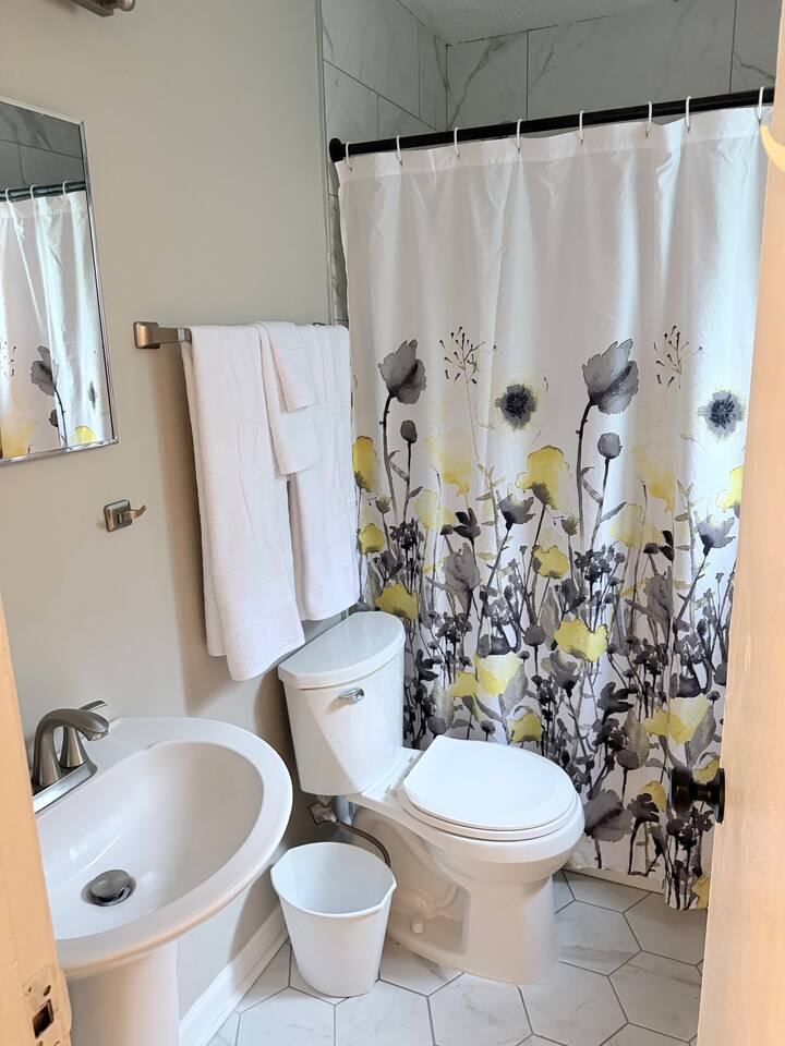 Updated full bathroom with fresh towels and tub/shower combination