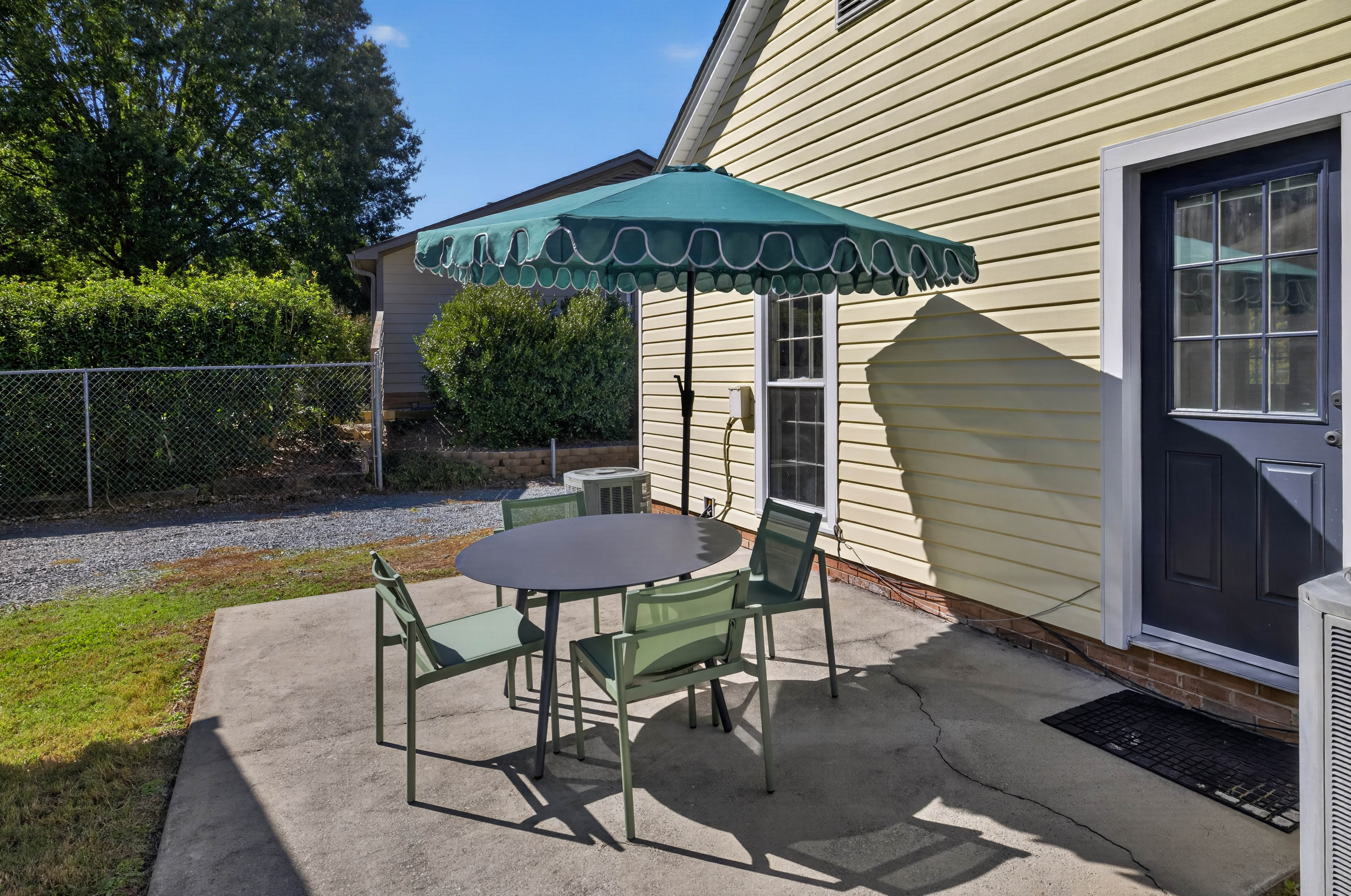 Private sunny patio with shaded outdoor dining for four