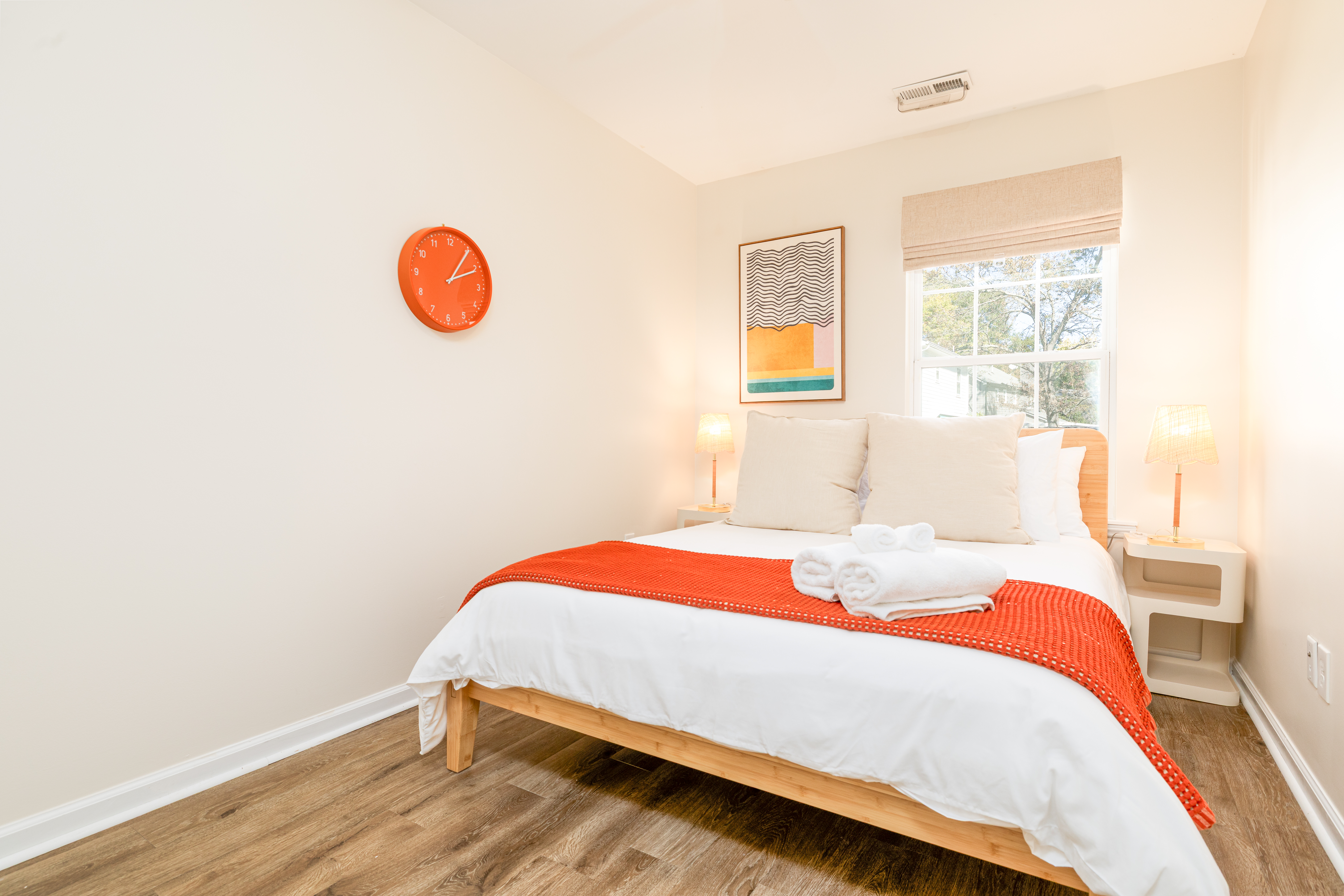 Bright, cozy bedroom with crisp linens, warm wood floors, and natural light