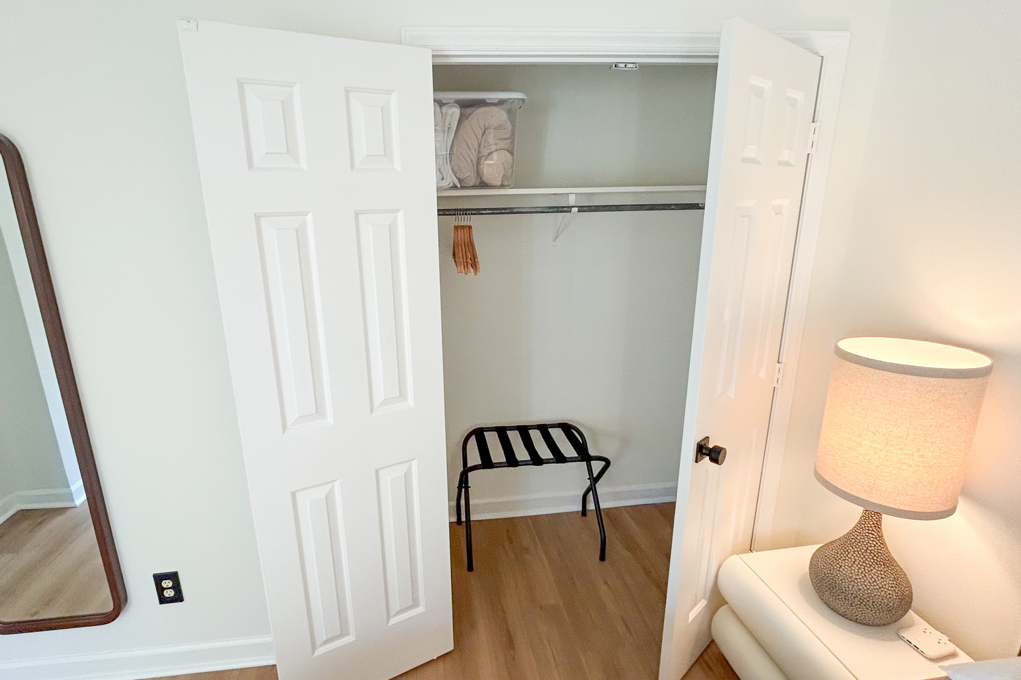 Main House closet with hangers and a luggage rack