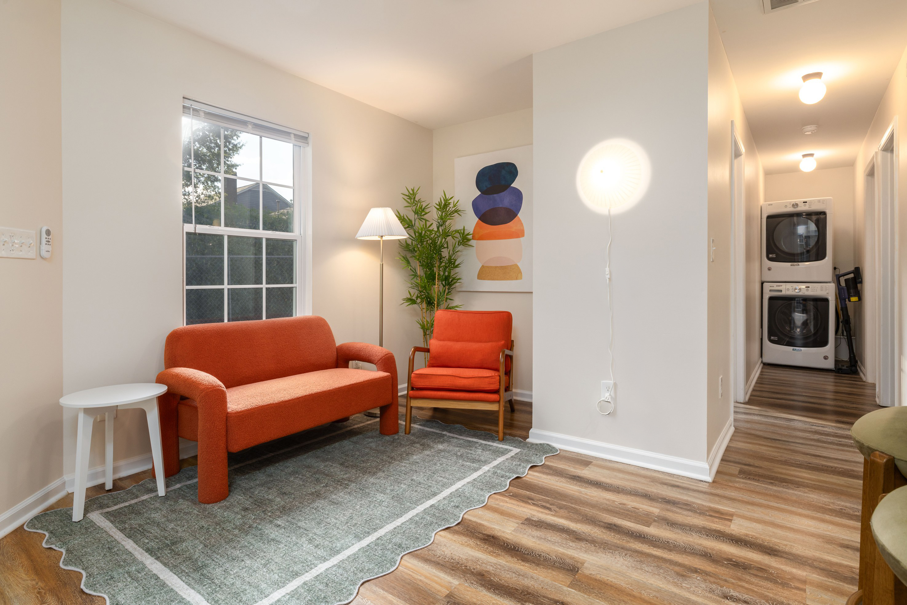 Two upholstered barstools at the Garden House kitchen counter, looking down the hall to the washer and dryer