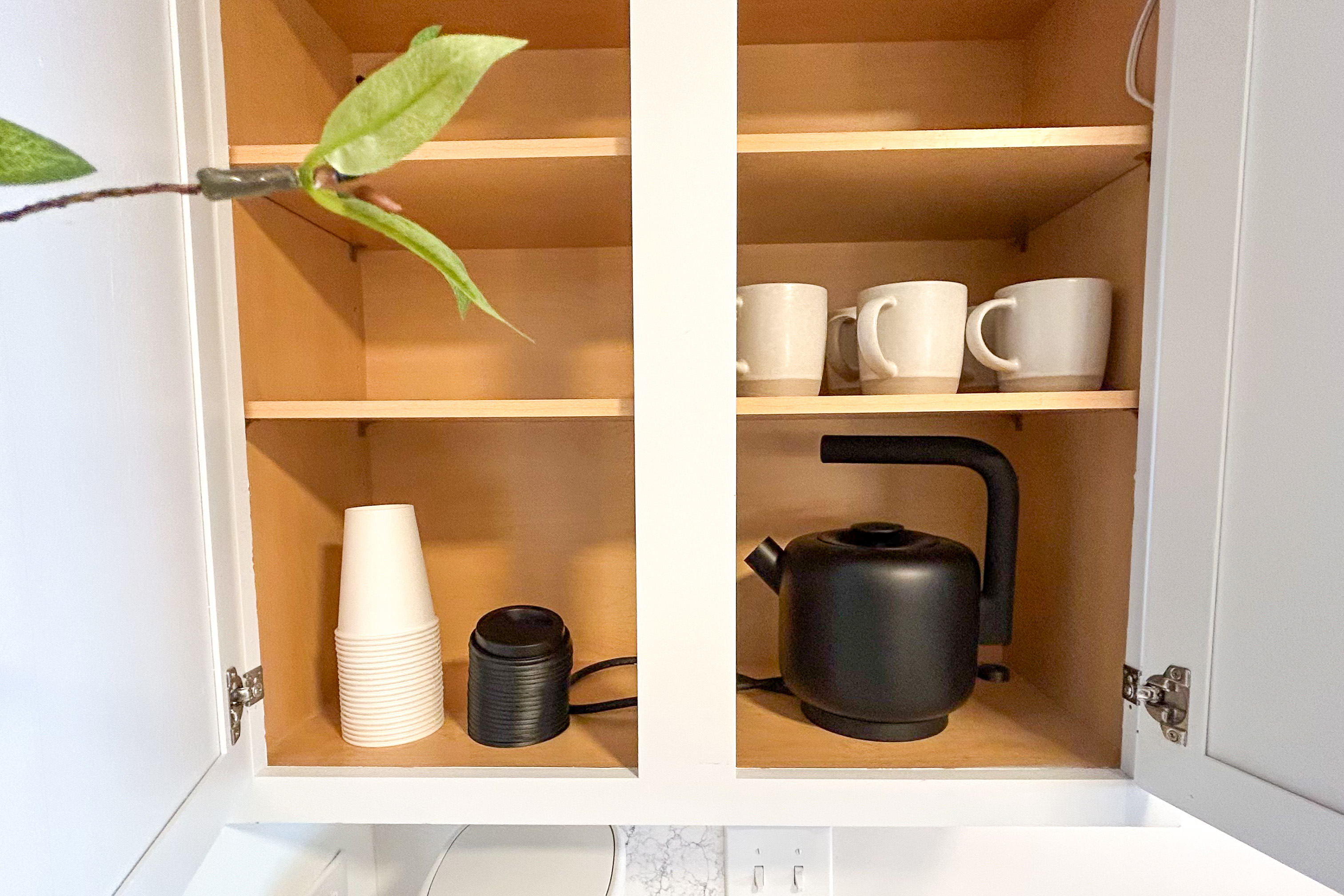 Main House coffee bar cabinet with mugs, to-go cups and an electric kettle