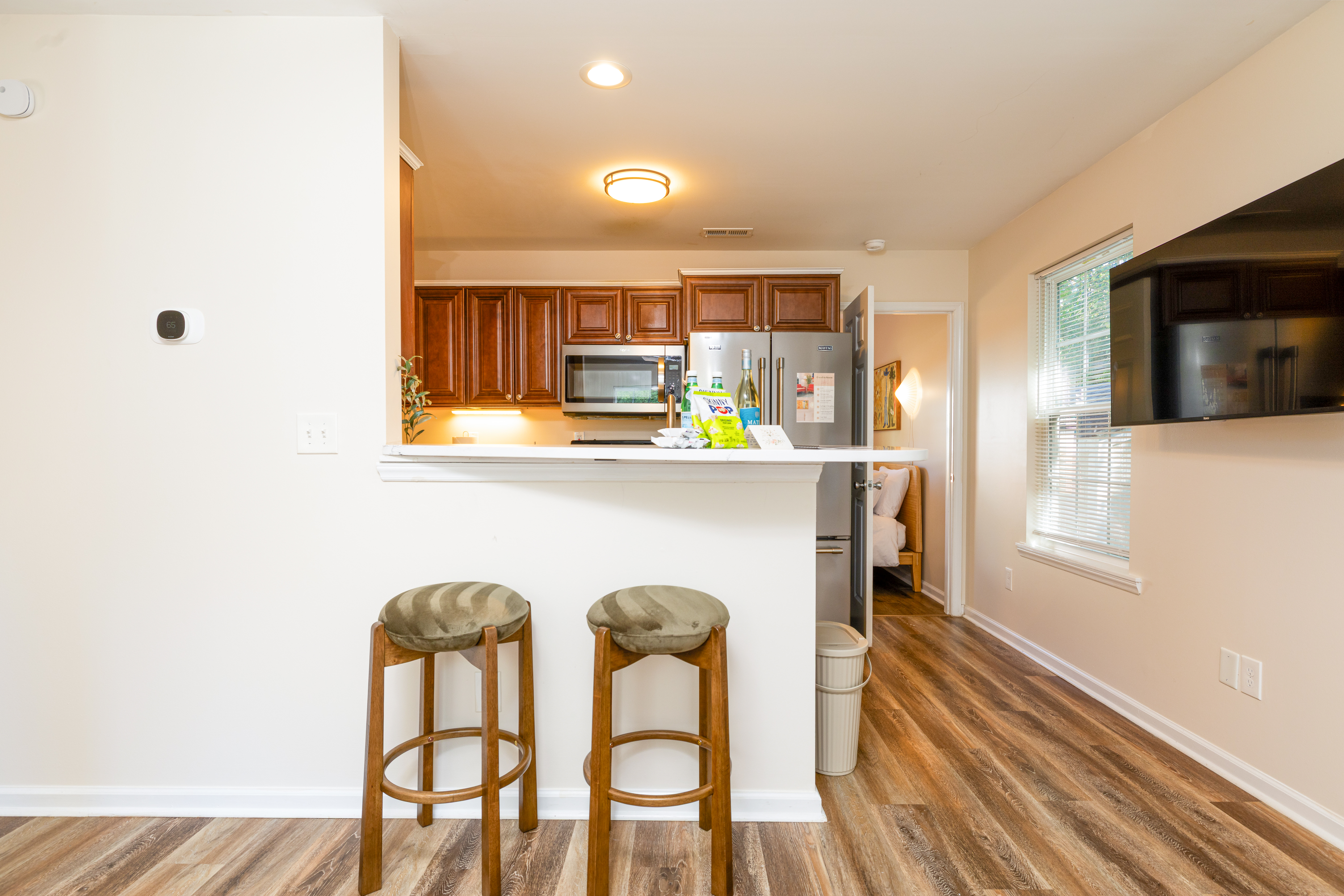 Bright kitchen with breakfast bar, stainless appliances, and TV