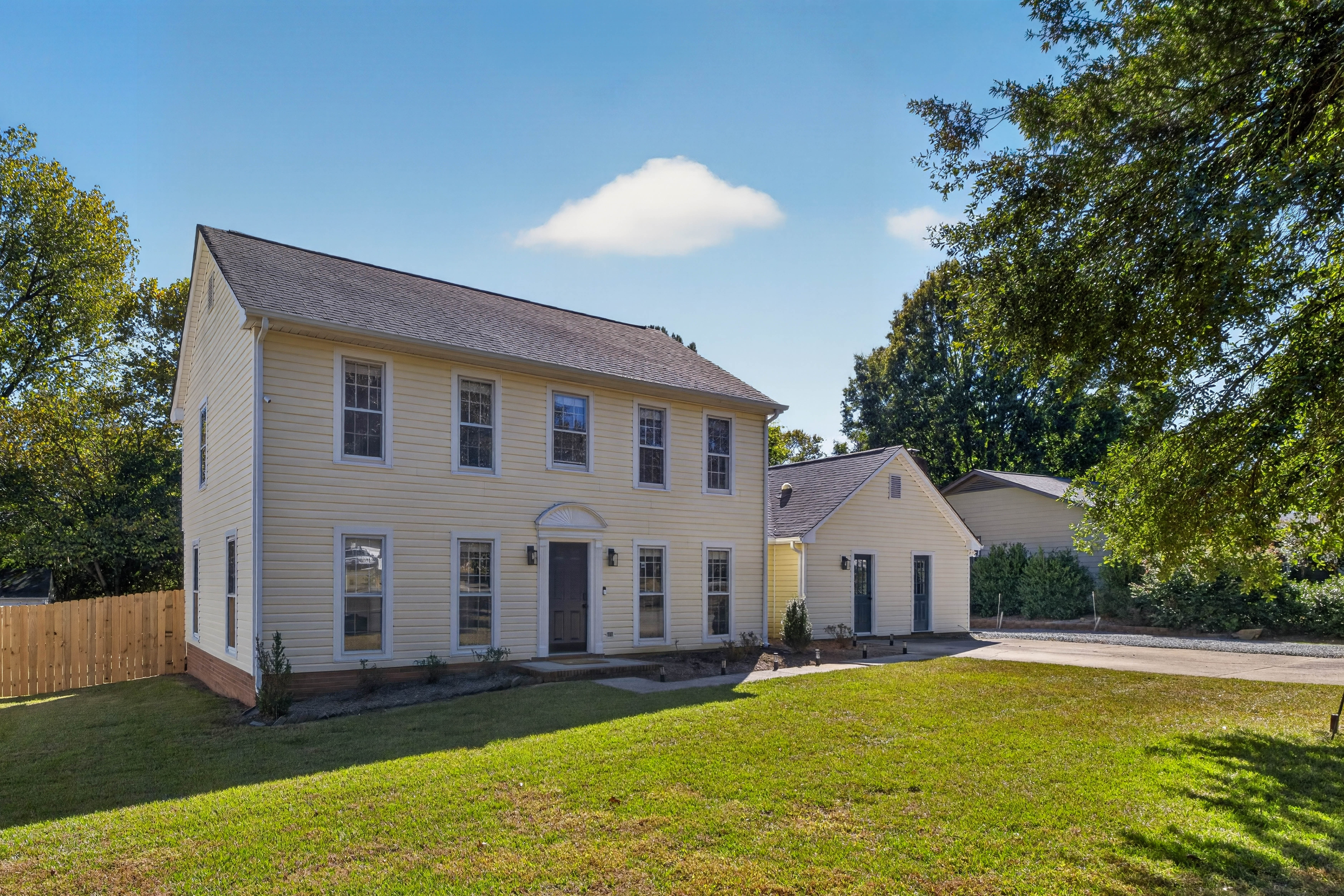 The Main House and its front lawn on a quiet, tree-lined street