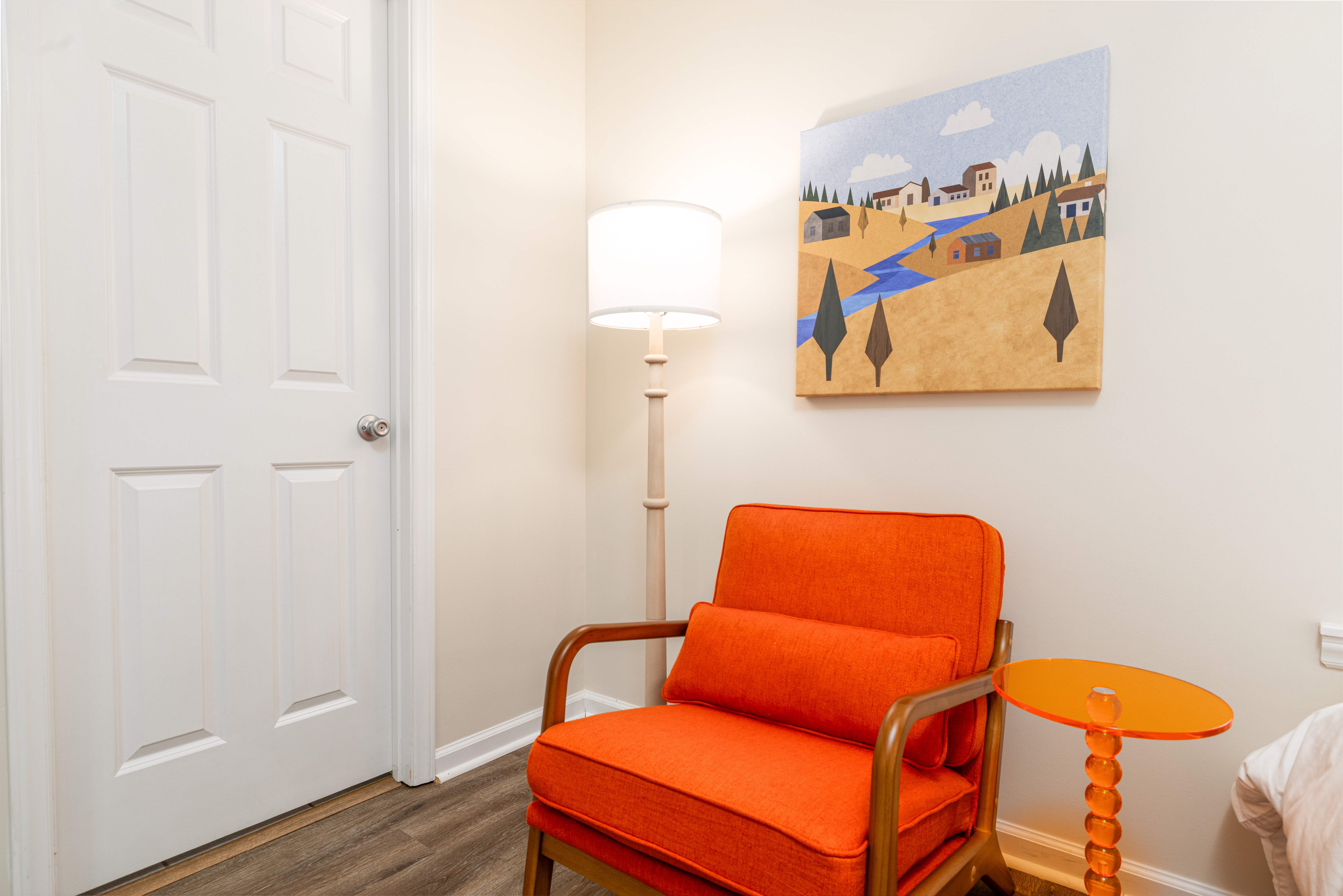 Cozy reading nook with bold accent chair, warm lighting, and modern art