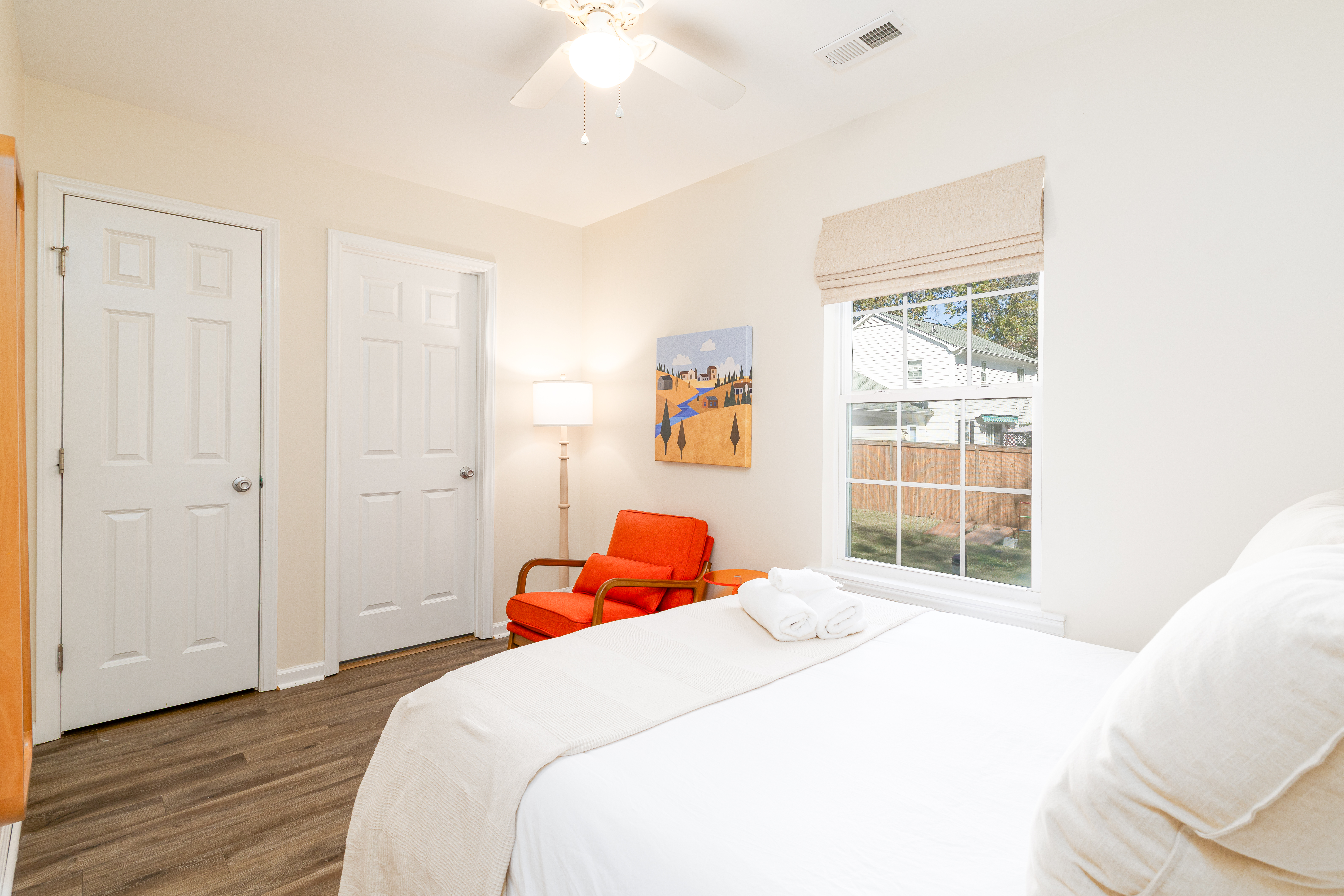 Bright cozy bedroom with yard views, accent chair, and natural light