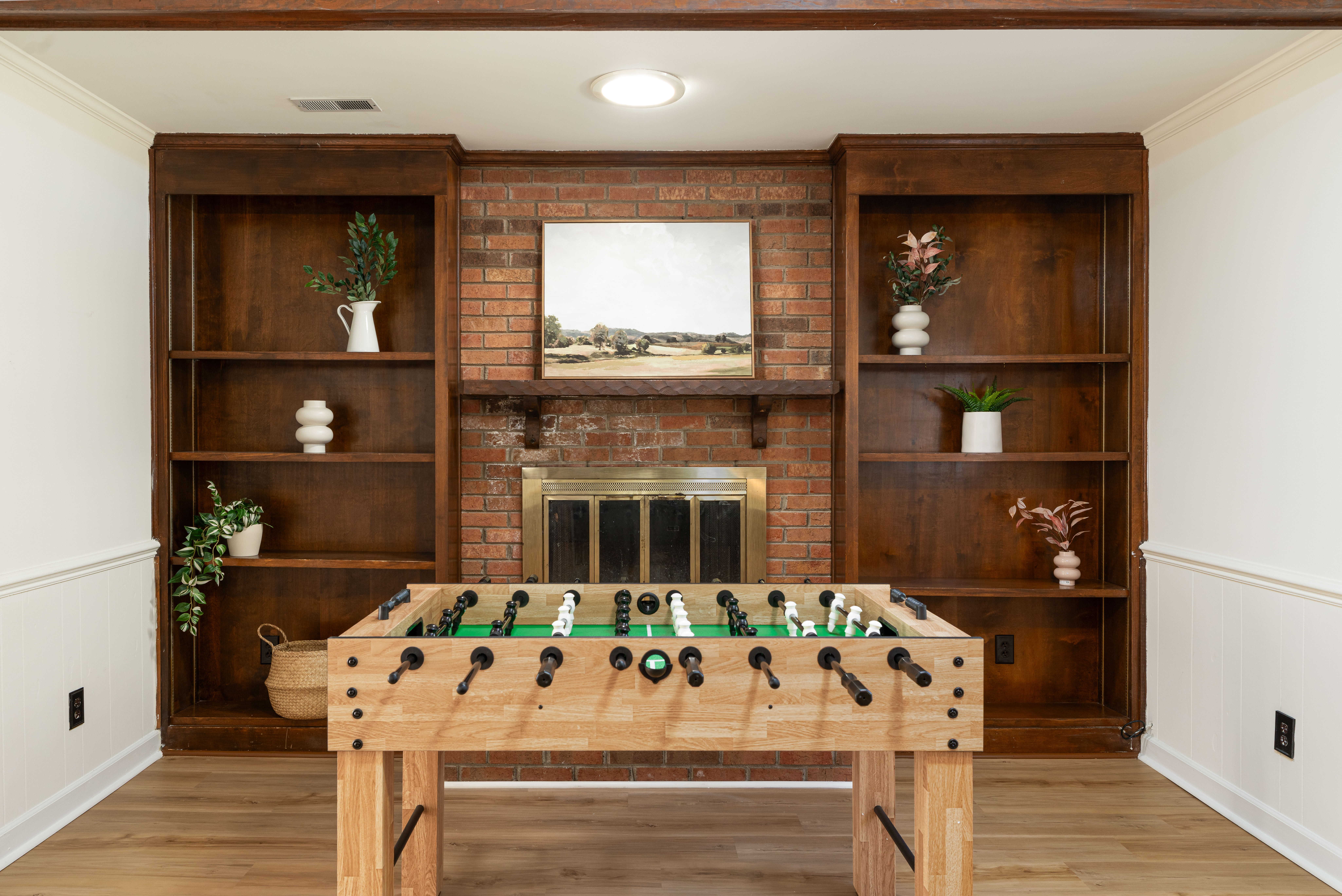 Main House family room with a full-size foosball table, brick fireplace and built-in shelves