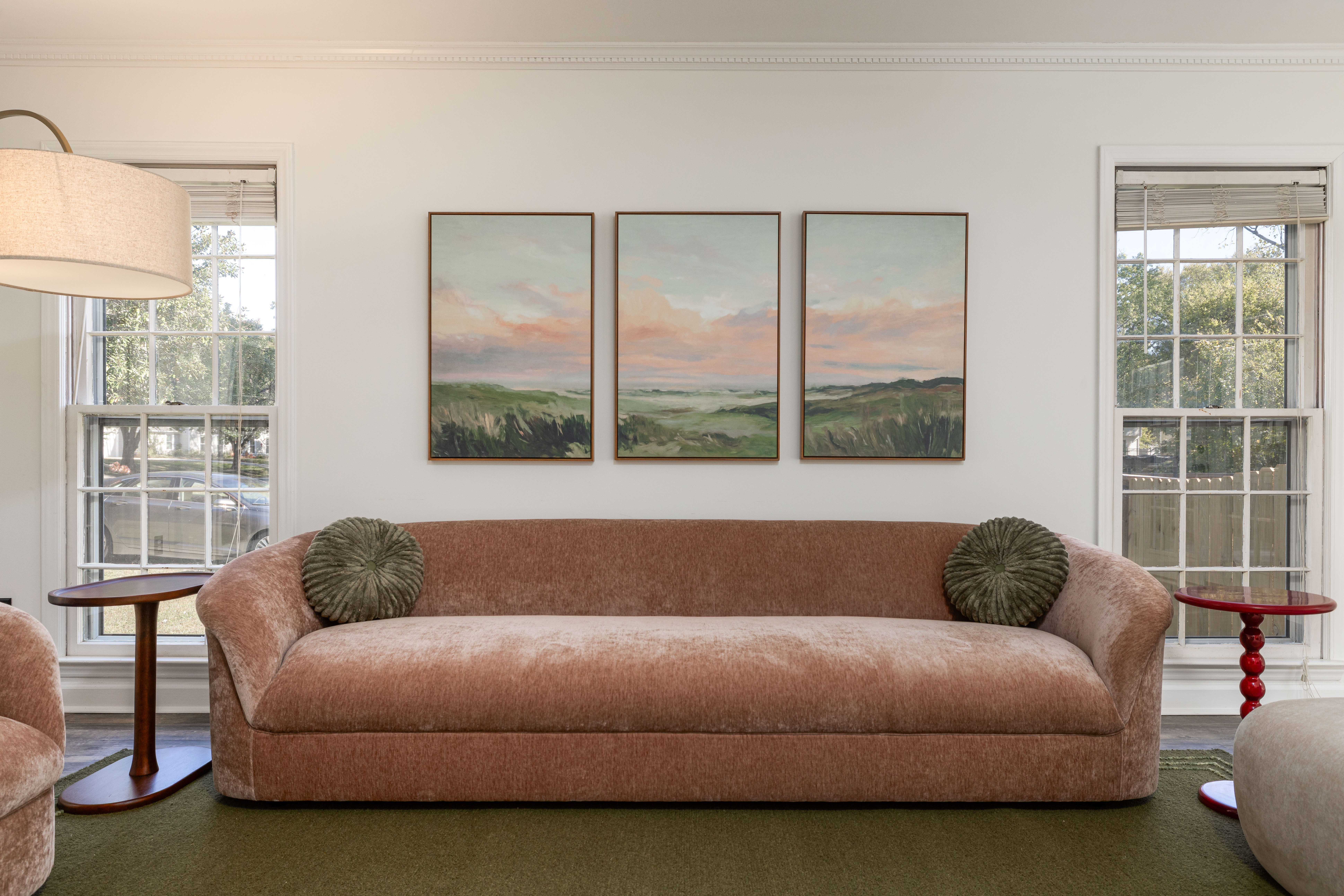 Main House living room sofa under a trio of landscape prints