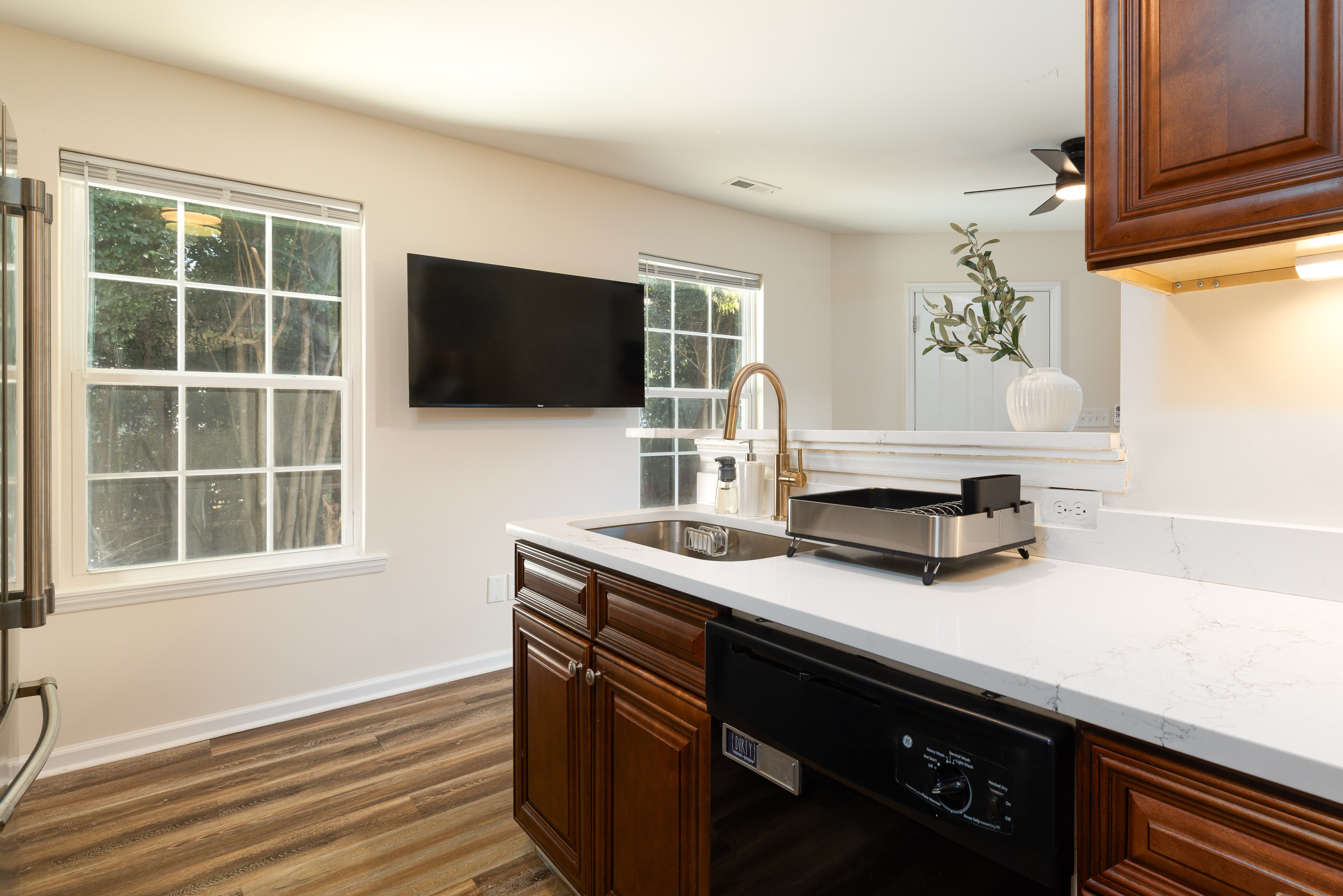 Garden House kitchen counter and dishwasher, with the wall-mounted TV beyond