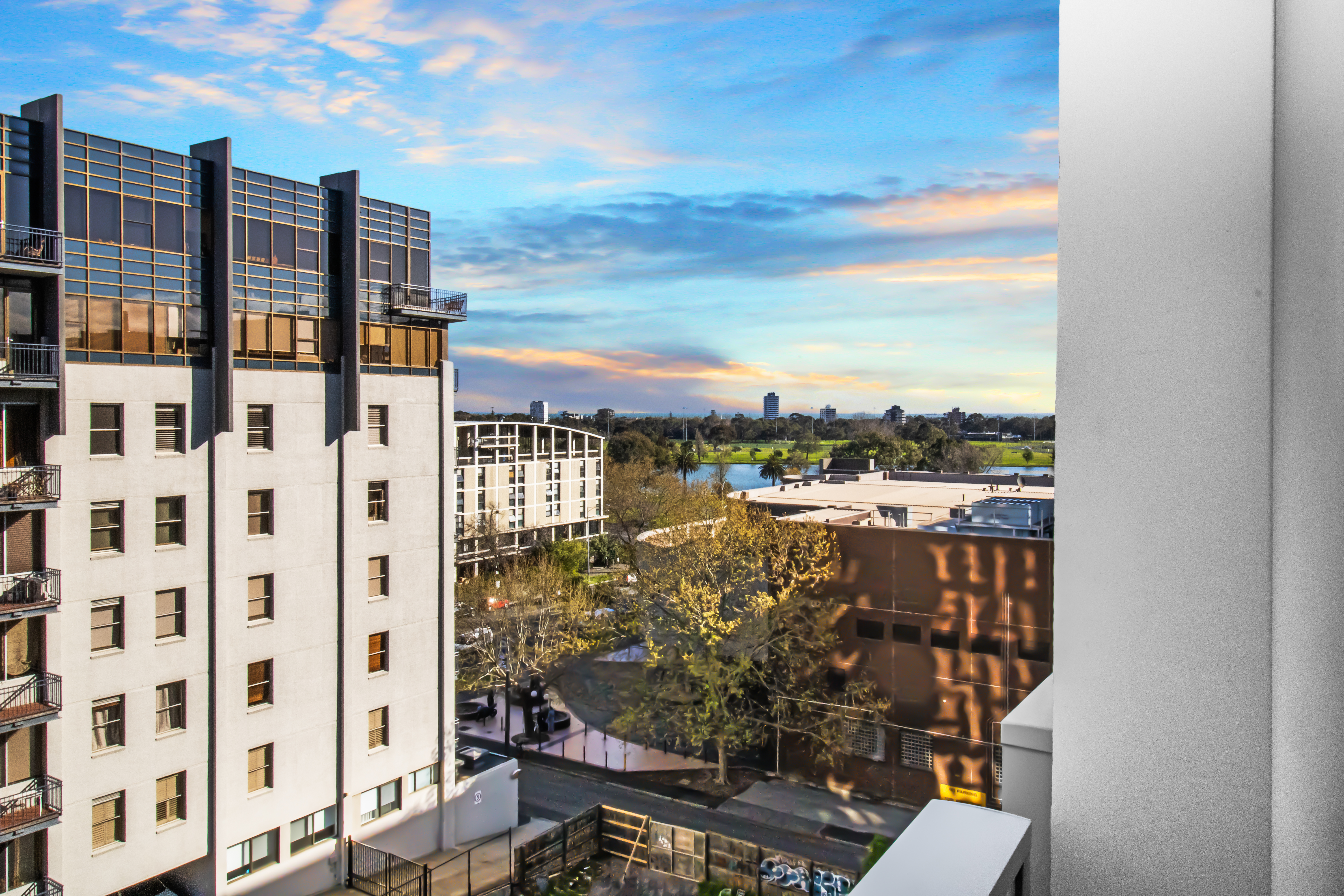 Elevated city views with leafy park outlook and colorful sunset sky