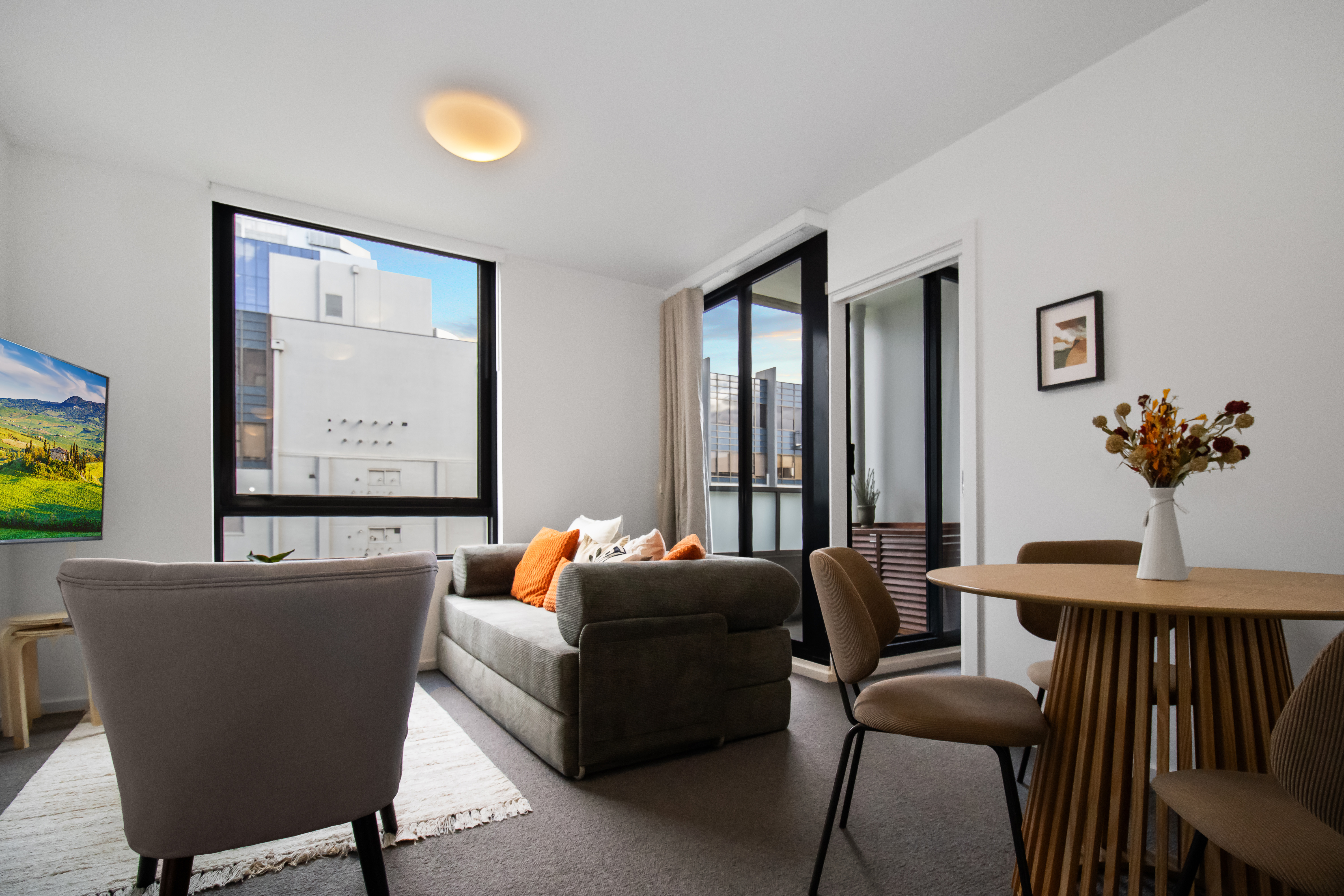 Bright modern lounge with balcony access and sunny city-view windows