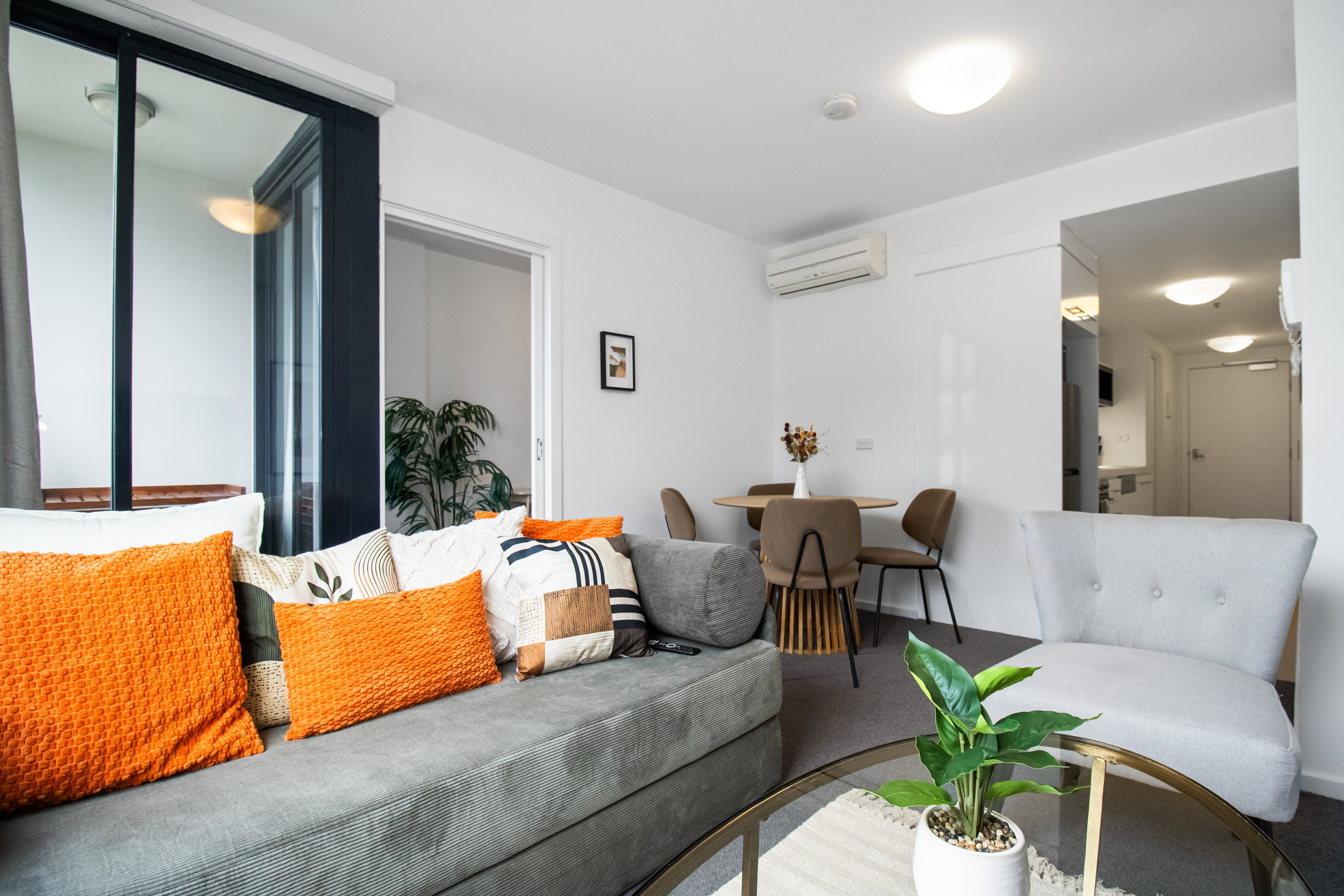 Bright modern lounge with cozy seating, dining nook, and natural light