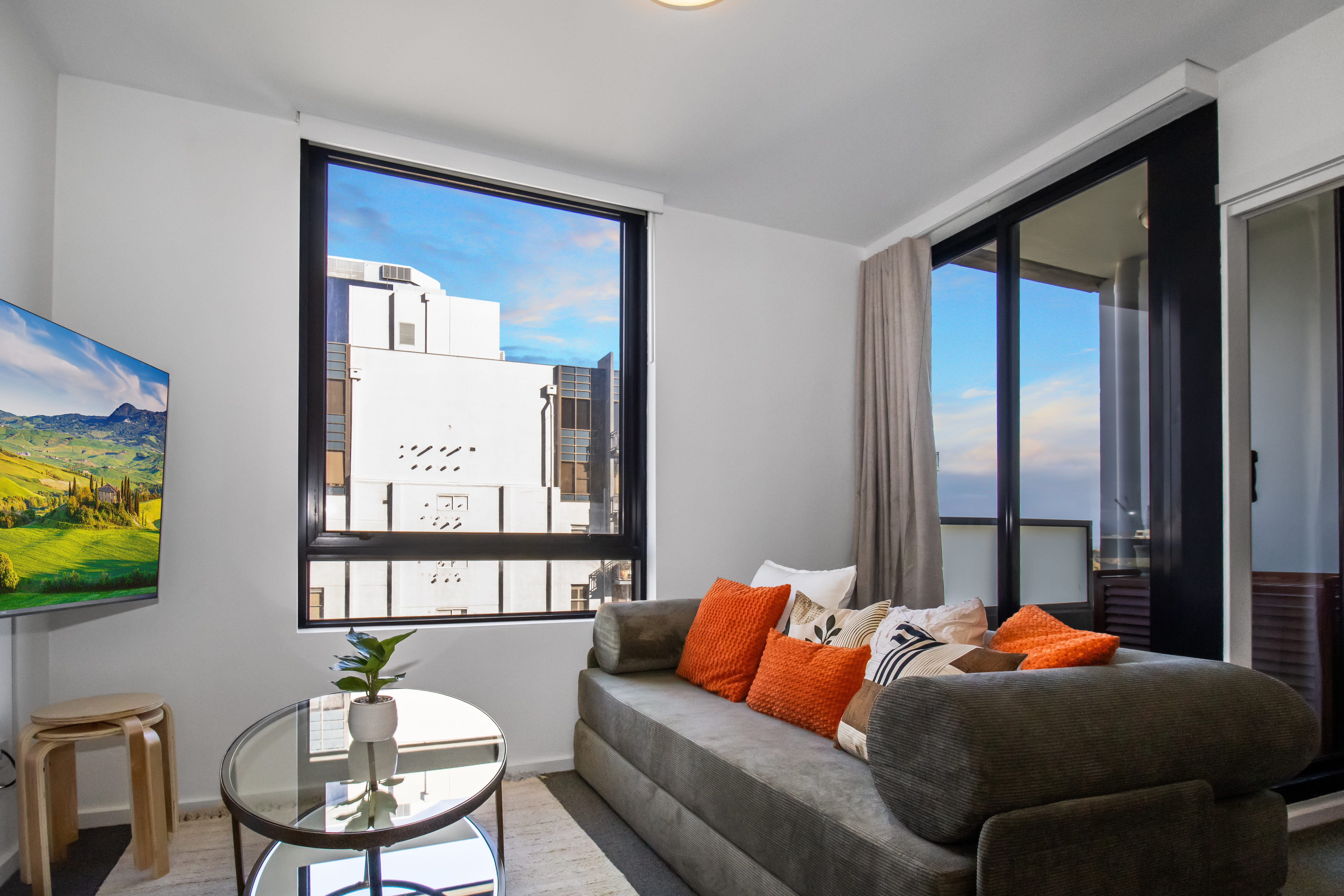 Bright modern lounge with balcony access and city-view windows