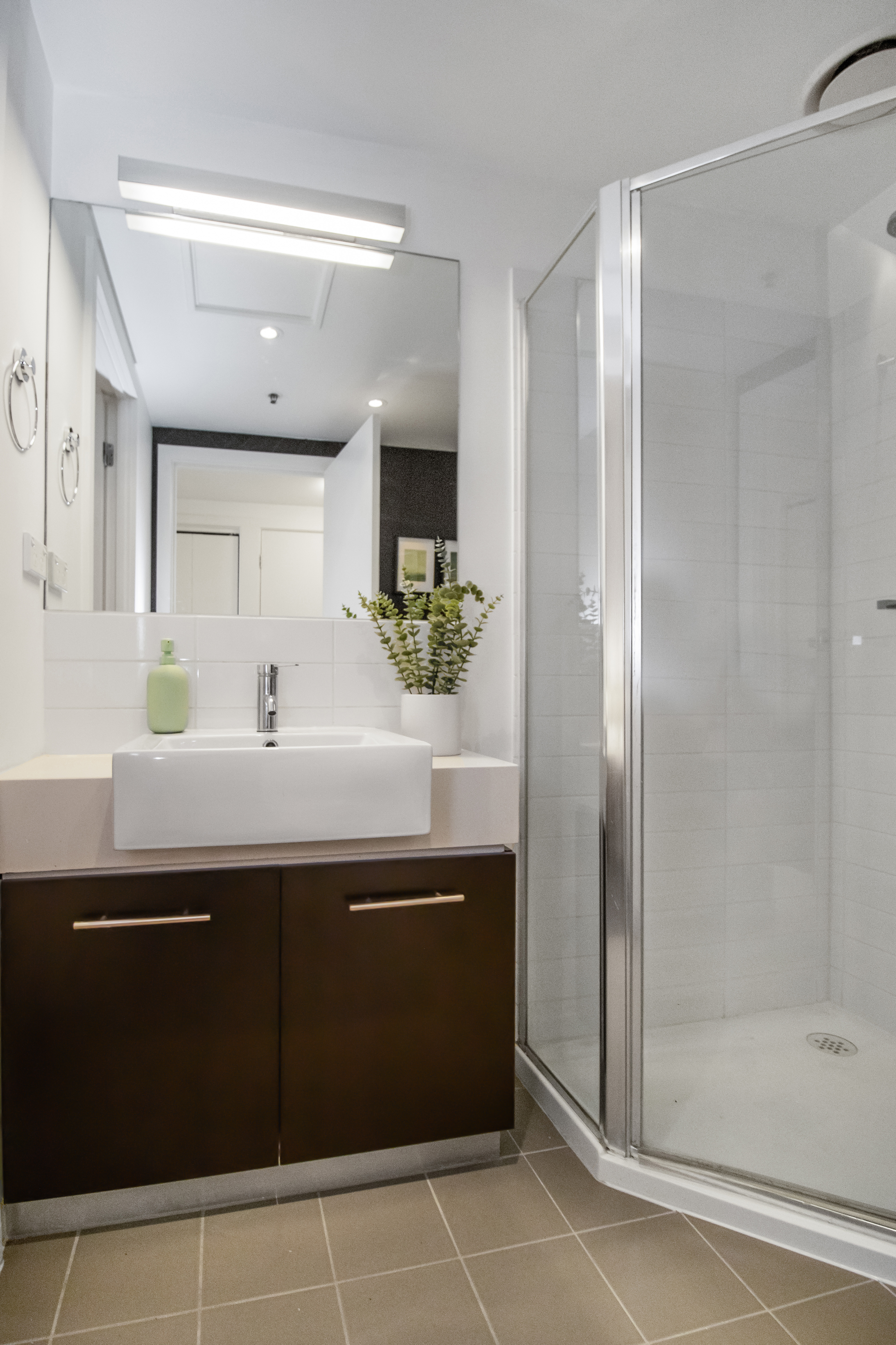 Modern bathroom with glass shower, sleek vanity, and bright clean design