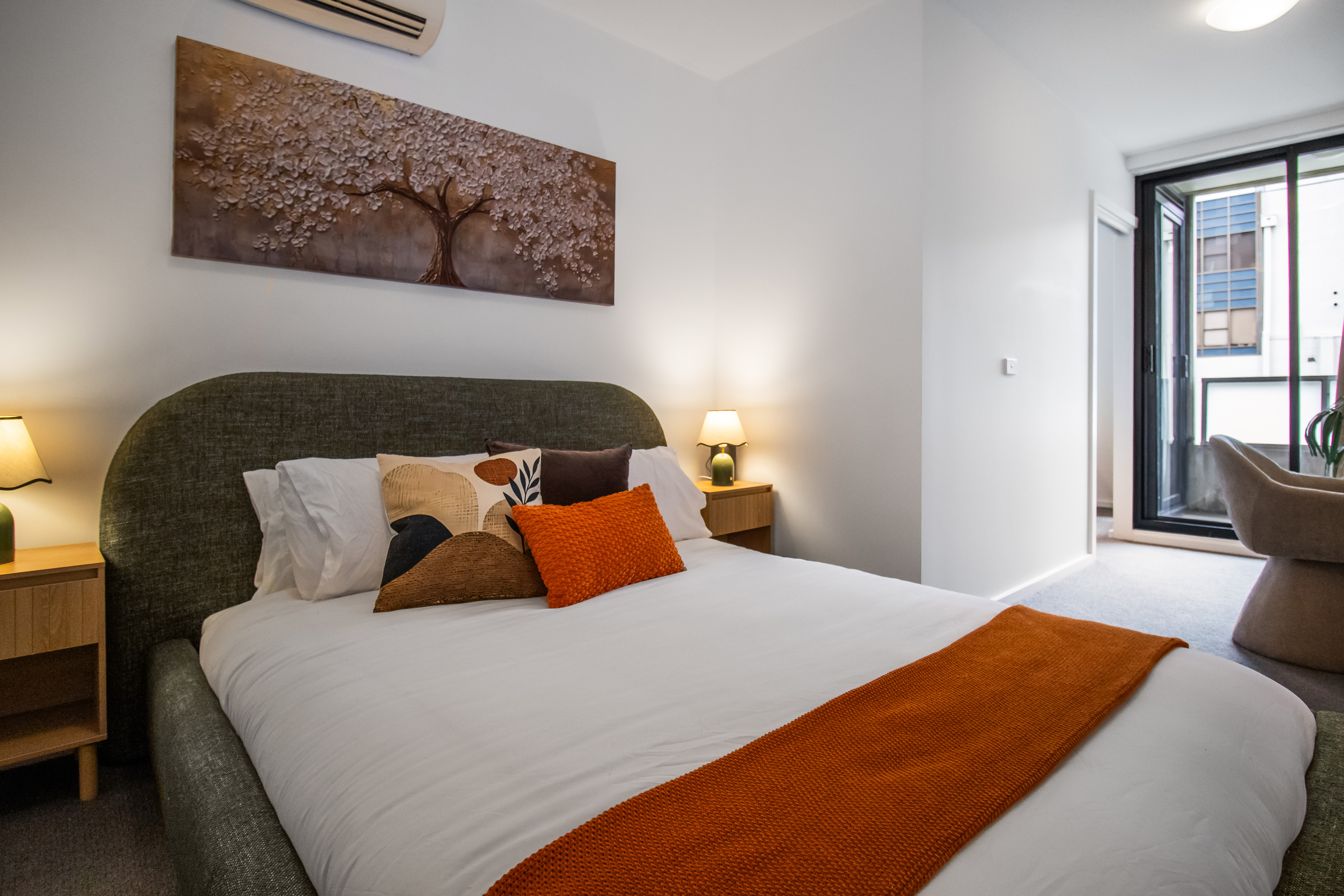 Bright modern bedroom with cozy styling, AC, and natural light