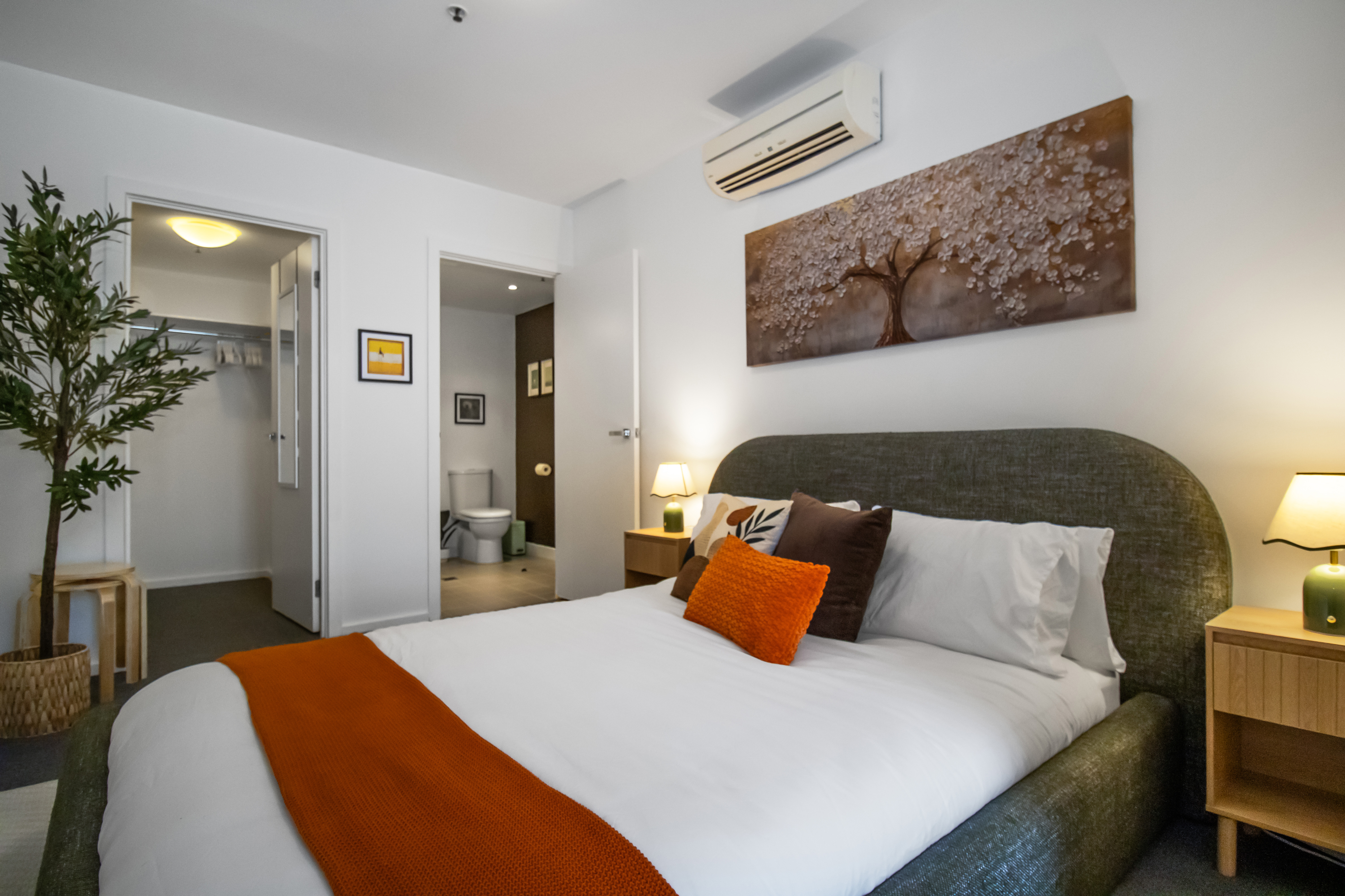 Cozy queen bedroom with en-suite bath, A/C, and warm modern touches