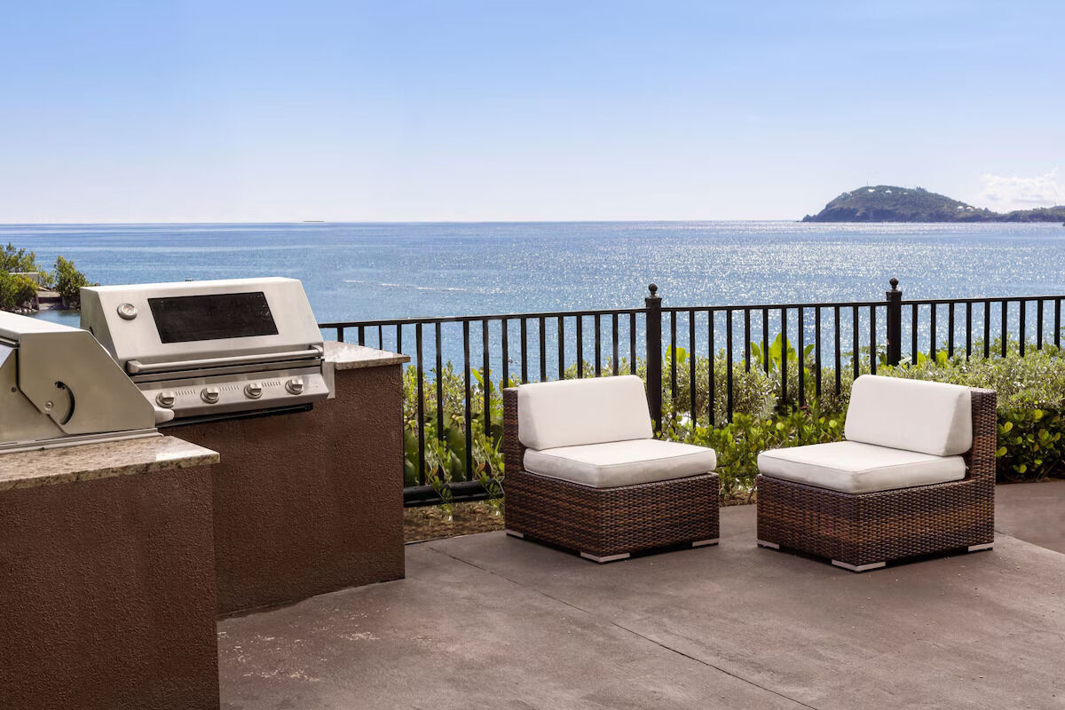 Oceanview patio with built-in grill and cozy outdoor lounge seating