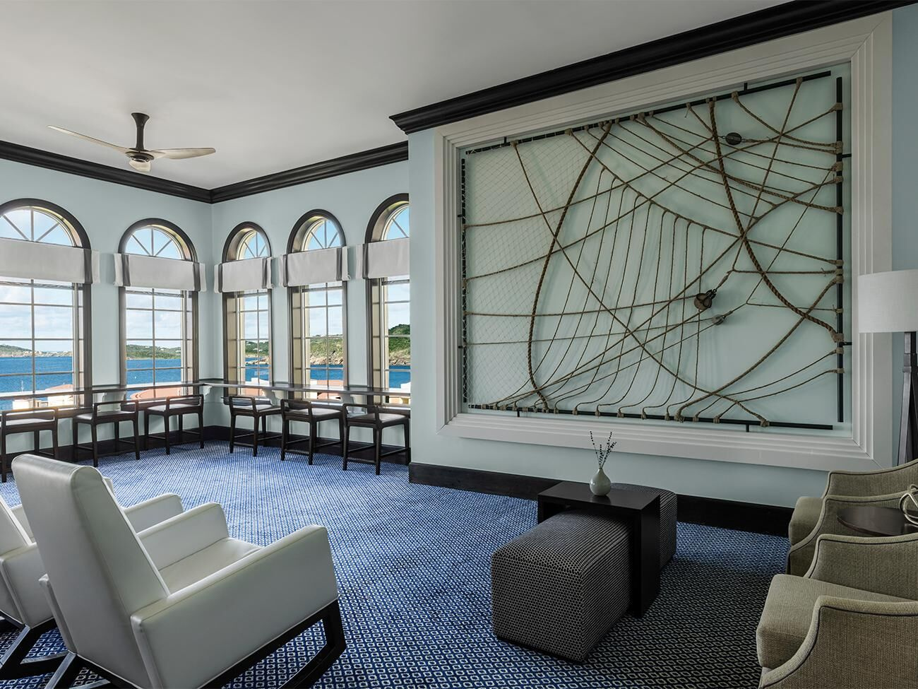 Bright waterfront lounge with arched windows and elegant seating
