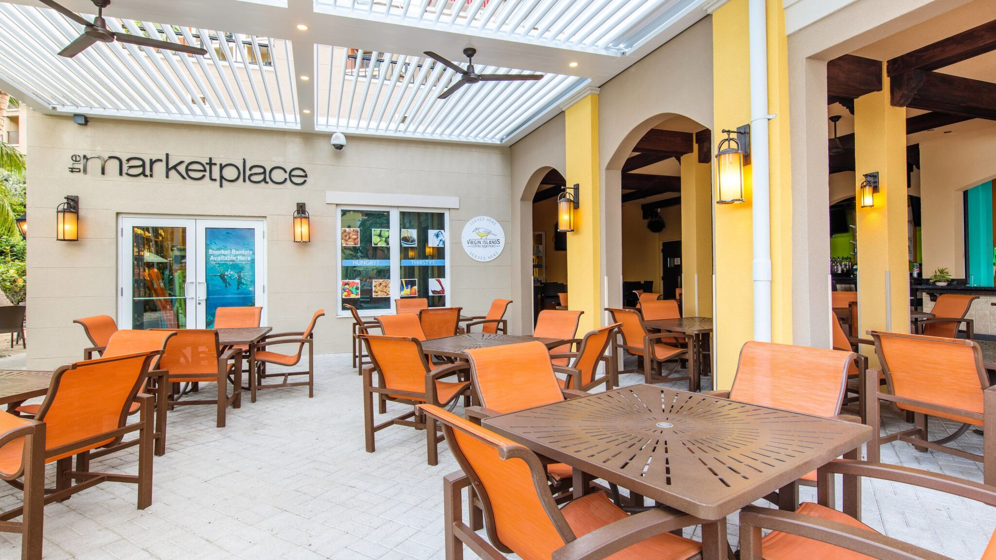 Inviting covered patio dining with resort-style seating and breezy fans