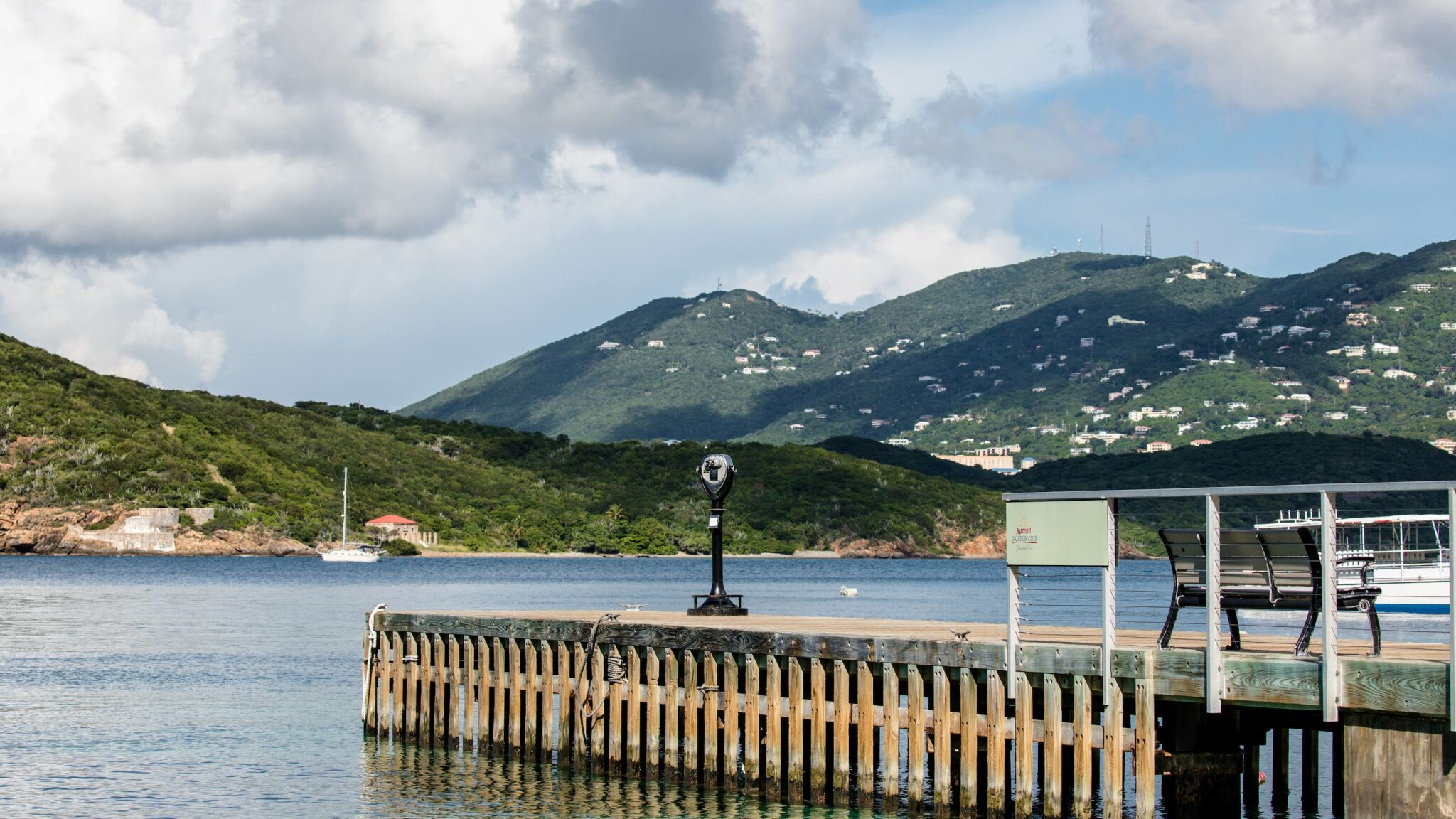 Scenic waterfront dock with calm bay views and lush island hills