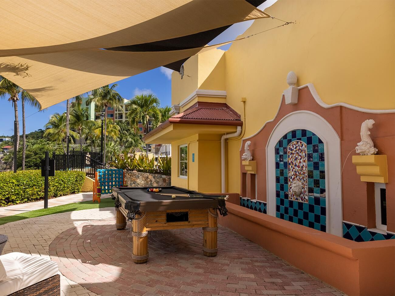 Shaded tropical patio with pool table and fun outdoor games