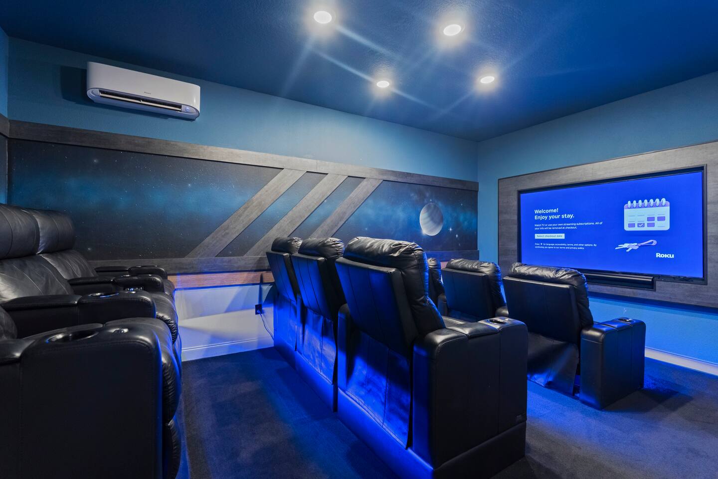 Private home theater with reclining leather seats and immersive blue lighting