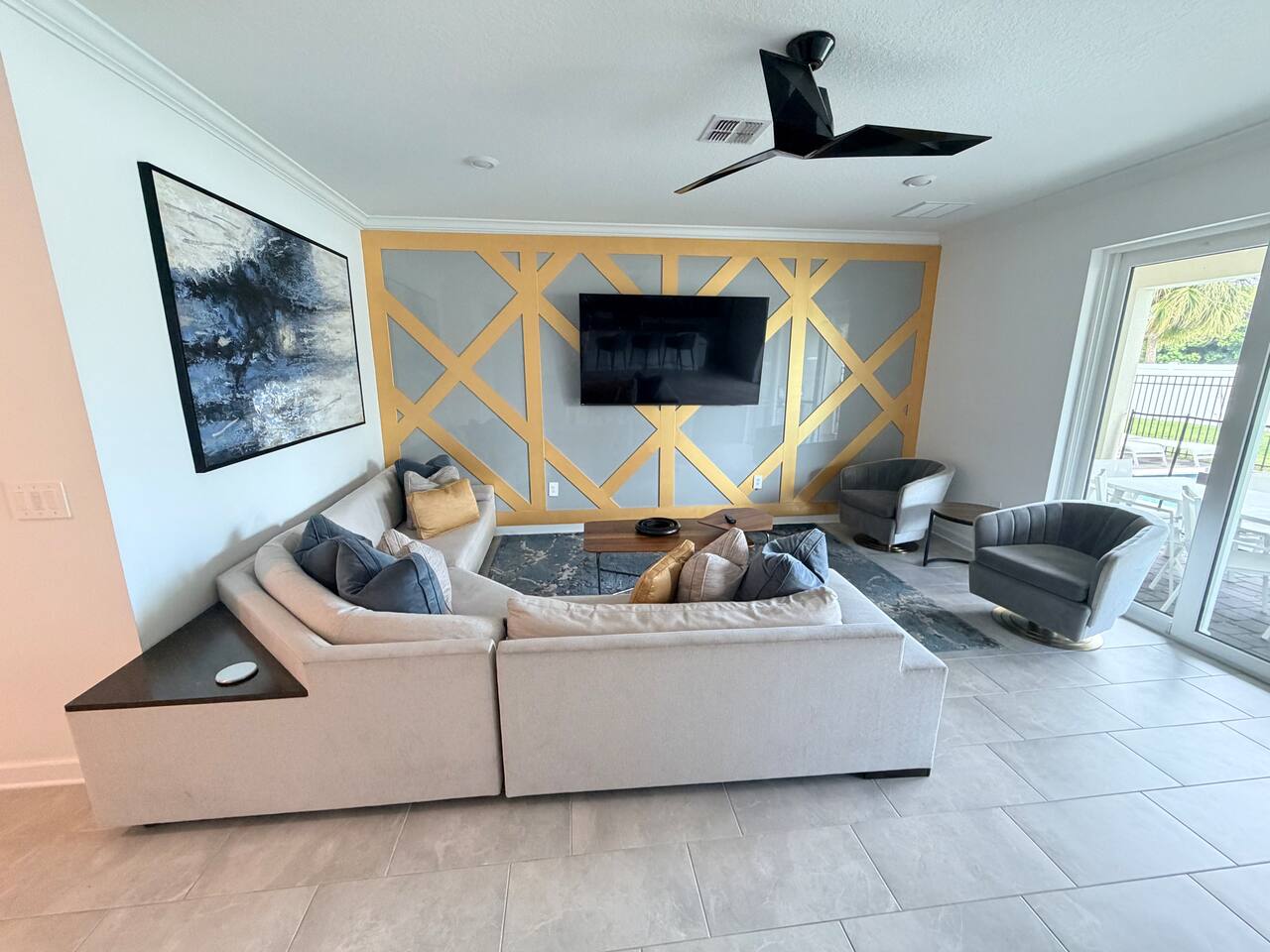 Modern lounge with statement accent wall, TV, and bright patio access