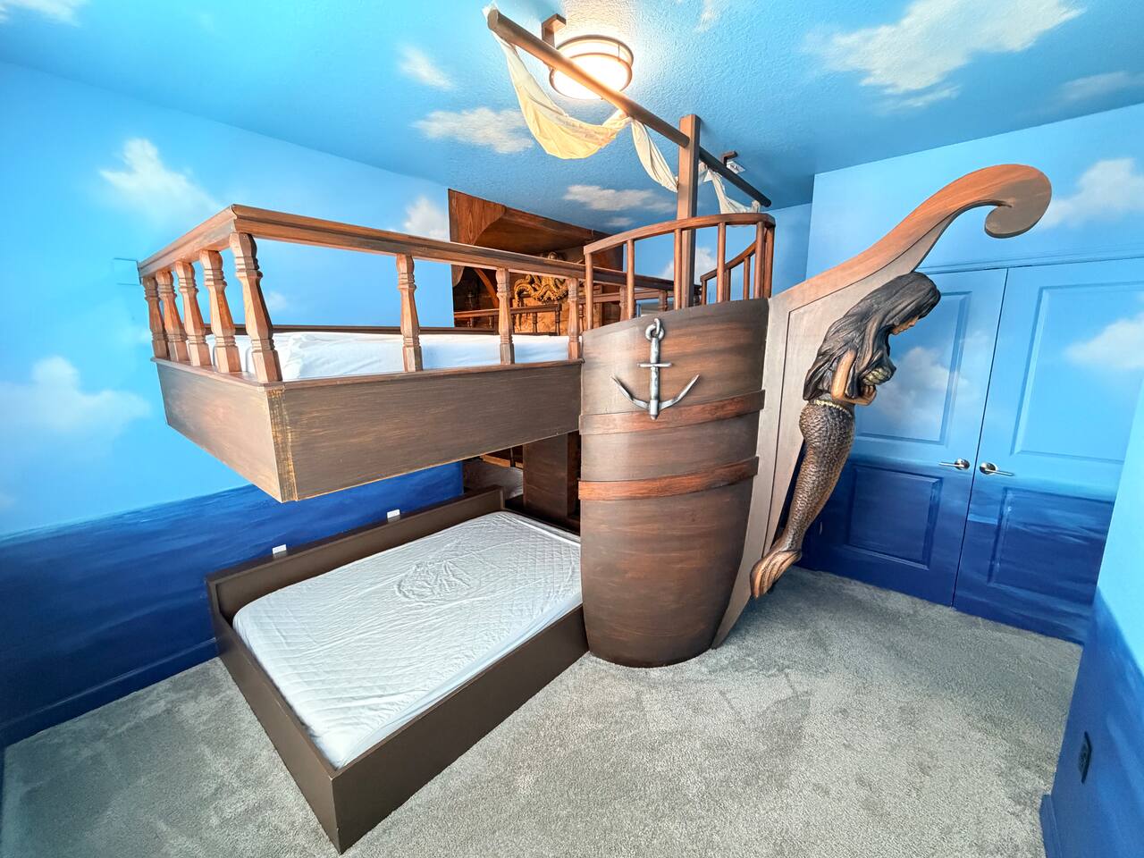 Epic pirate ship bunk room with ocean mural and fun family sleeping space
