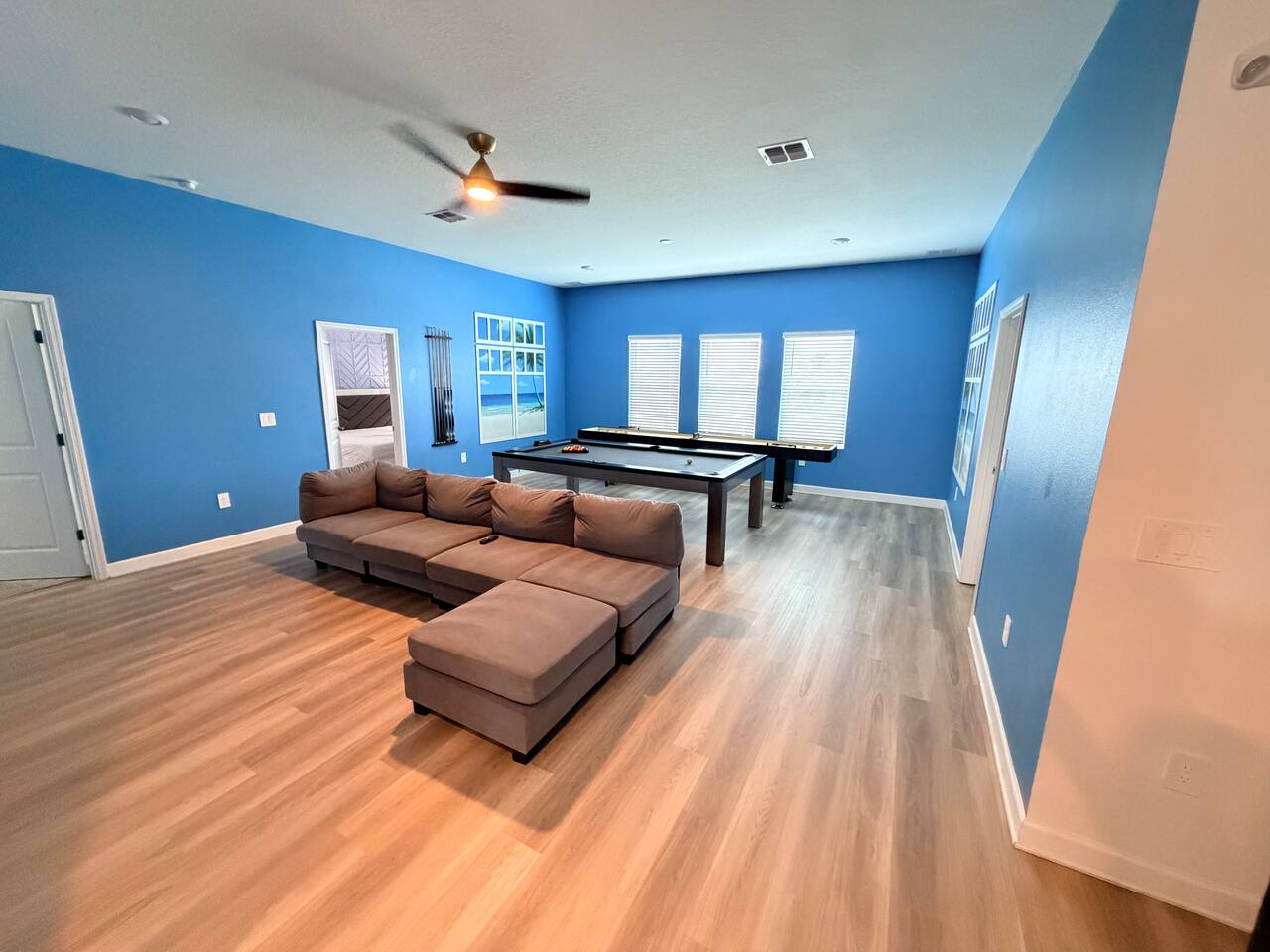 Spacious game room with pool table and comfy sectional lounge