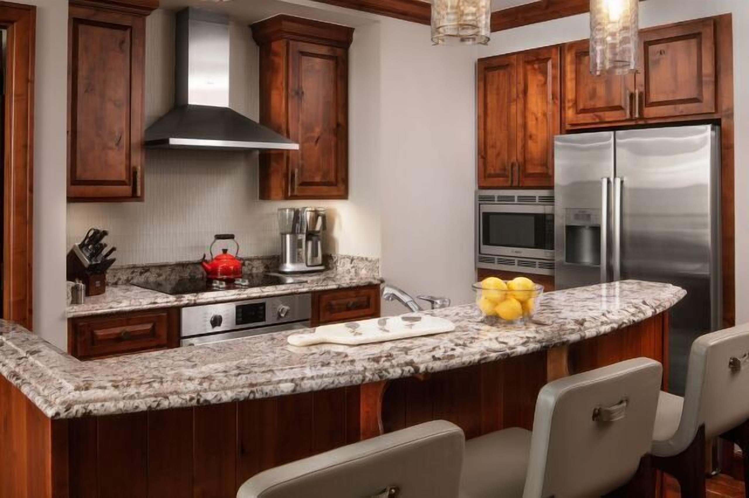 Granite breakfast bar and upscale kitchen with warm wood finishes