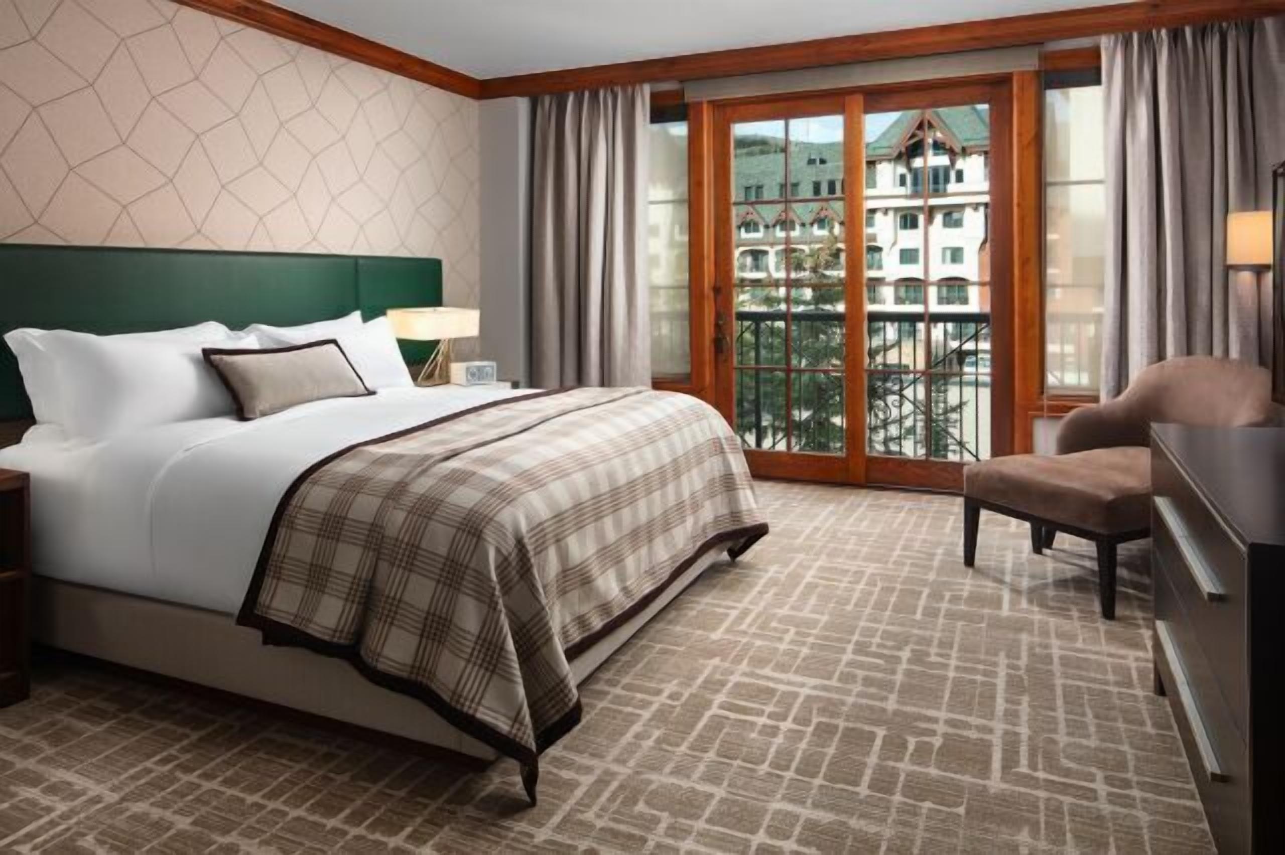 Bright, elegant bedroom with balcony views and cozy lounge seating