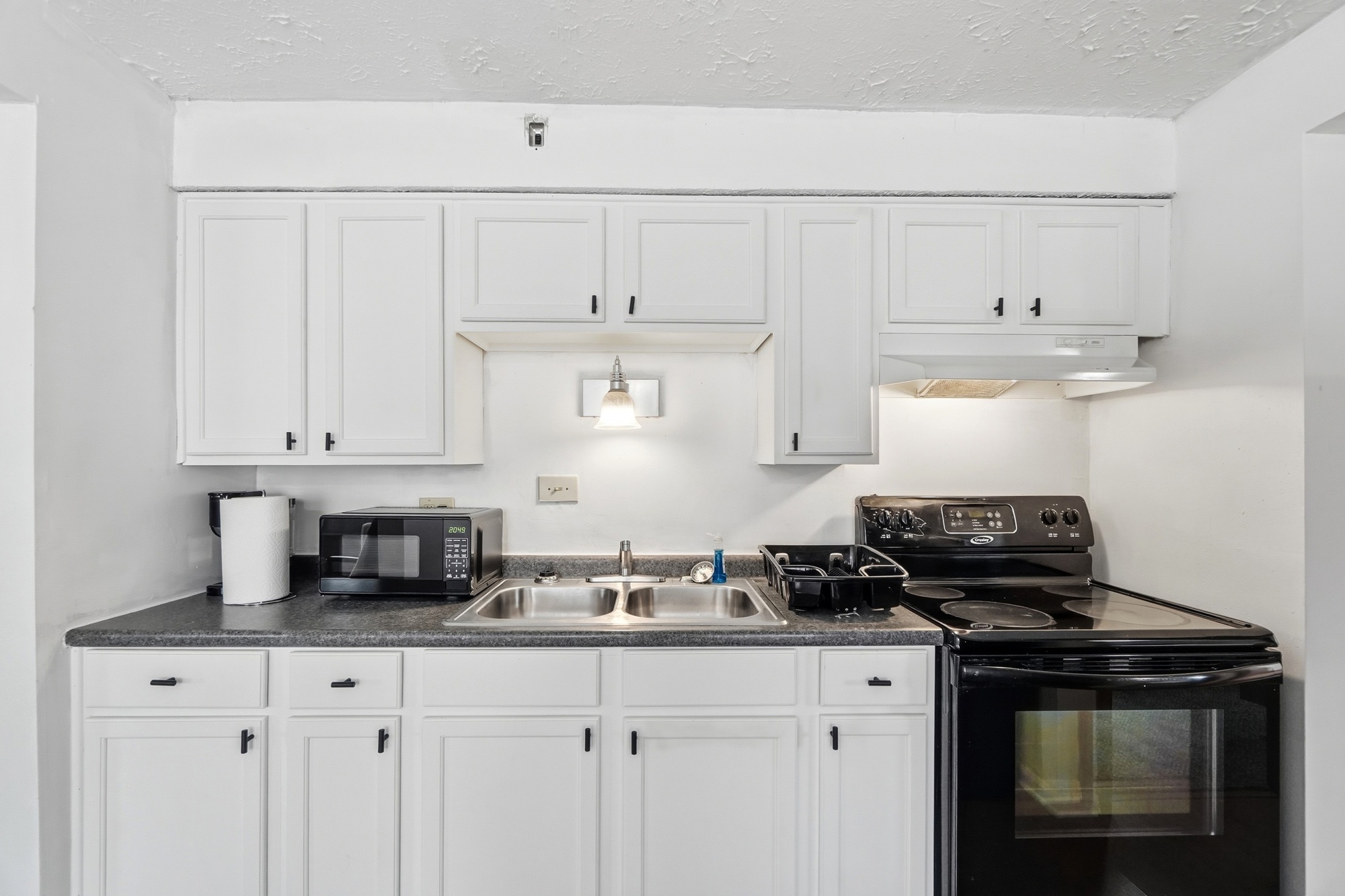 Bright, practical kitchen with full stove, microwave, and ample cabinet space