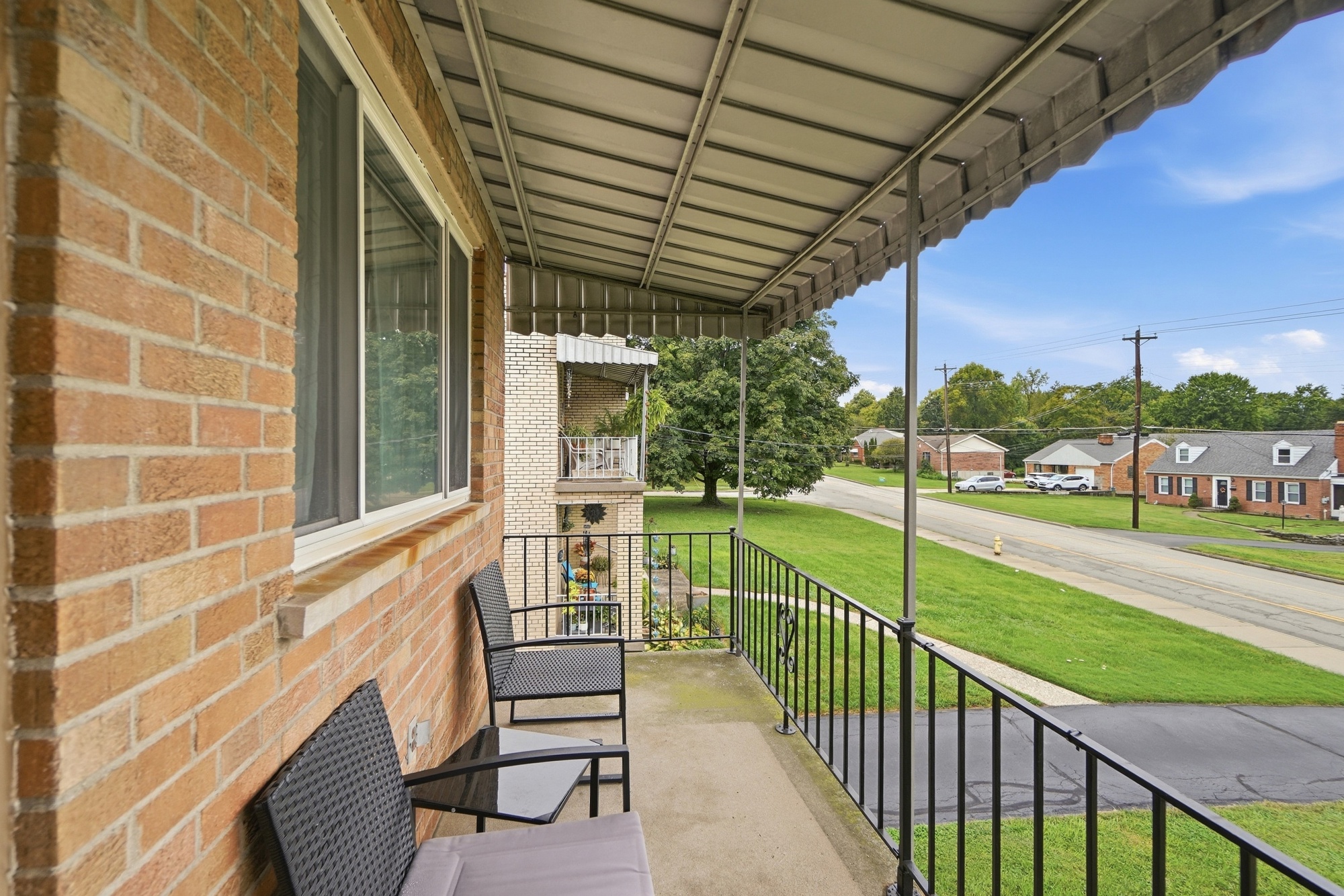 Covered front porch with seating and a peaceful neighborhood view