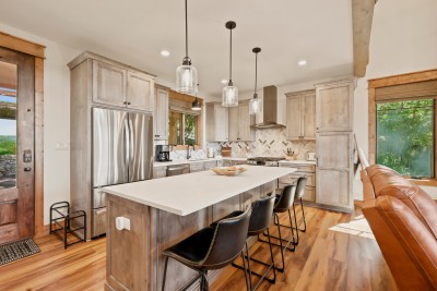 Step in from the front door and the kitchen is right there, so grocery bags land on the quartz island in seconds. Four barstools pull up for breakfast, the gas range and coffee maker sit within reach, and the leather recliners are only steps away.