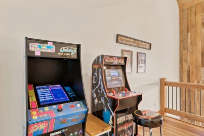 Retro arcade loft with classic games and rustic cabin charm. Two full-size cabinets hold Ms. Pac-Man, Galaga, Mortal Kombat II and dozens more, so pull up the stool, settle the high-score debate and hand the joystick to whoever claims they can win.