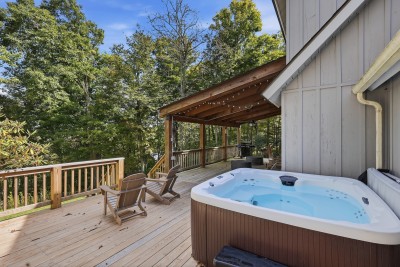 Your private wooded deck pairs a hot tub that seats 8 with Adirondack chairs and a covered lounge strung with lights, a few paces from the back door. Soak after a ski day while tall hardwoods screen the yard and the stone fire pit waits on the lawn
