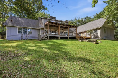 Spacious backyard and covered deck in a peaceful wooded setting