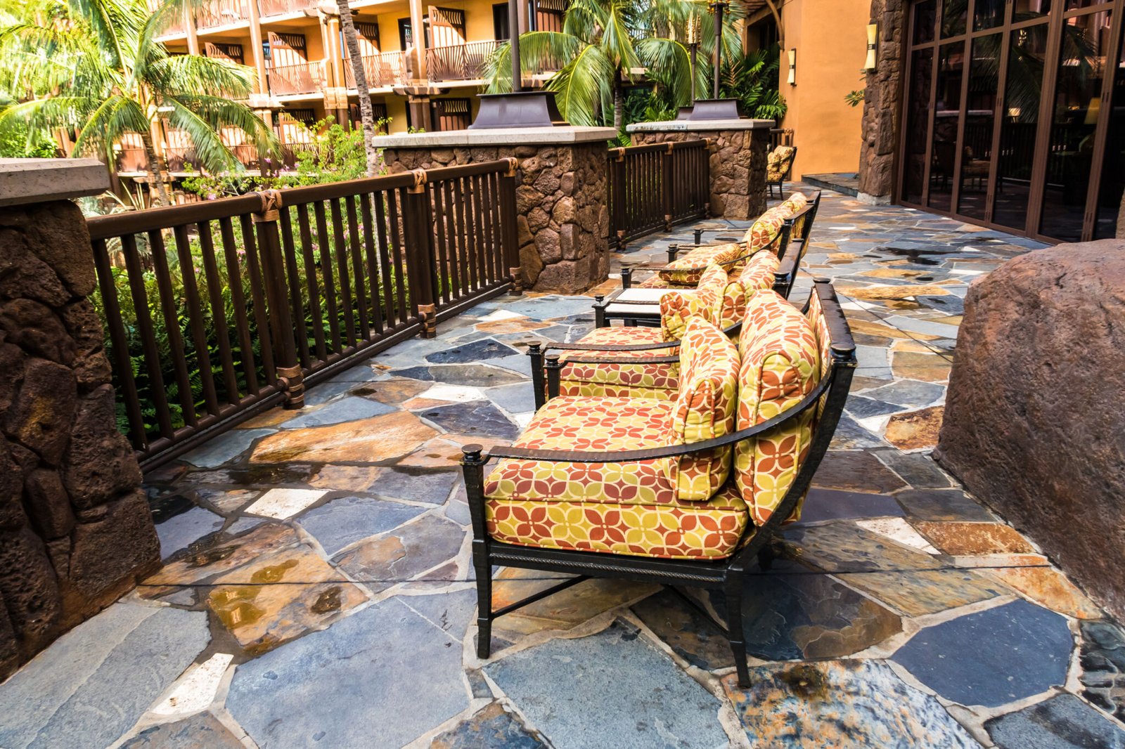 Tropical stone terrace with cushioned seating and serene resort views
