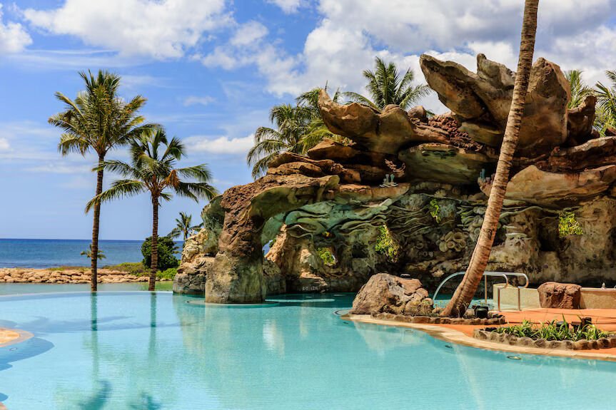Oceanfront lagoon pool with tropical palms and stunning rock grotto
