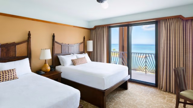 Bright double-queen room with private balcony and stunning ocean view