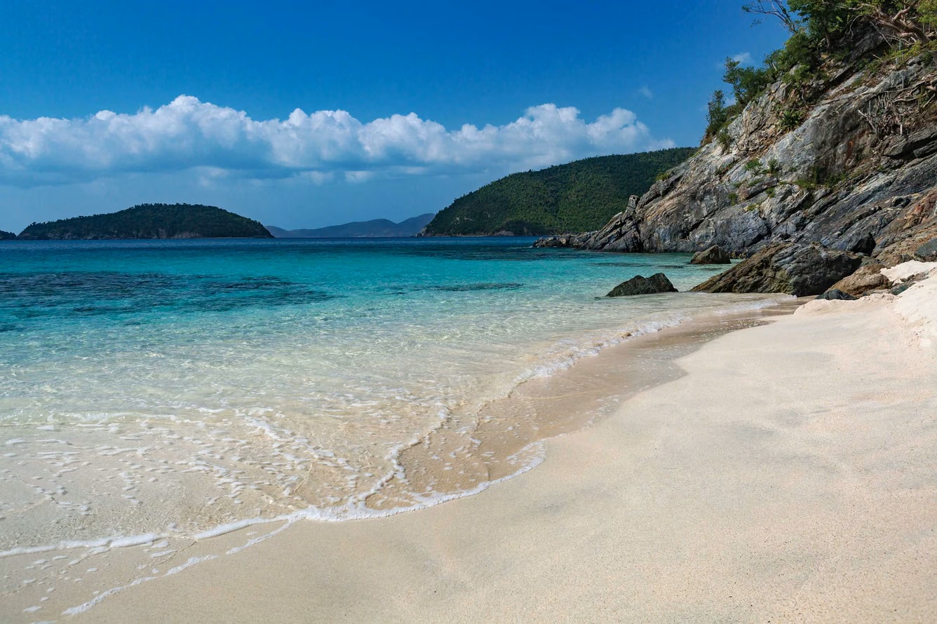 Secluded white-sand beach with crystal-clear water and tropical views