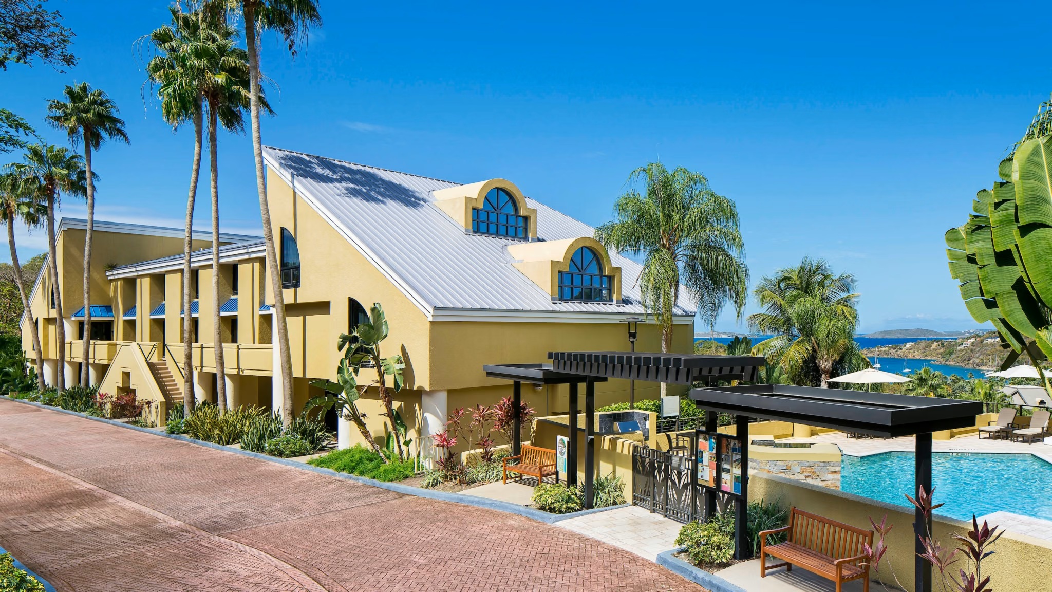 Tropical resort-style stay with pool, palms, and ocean views